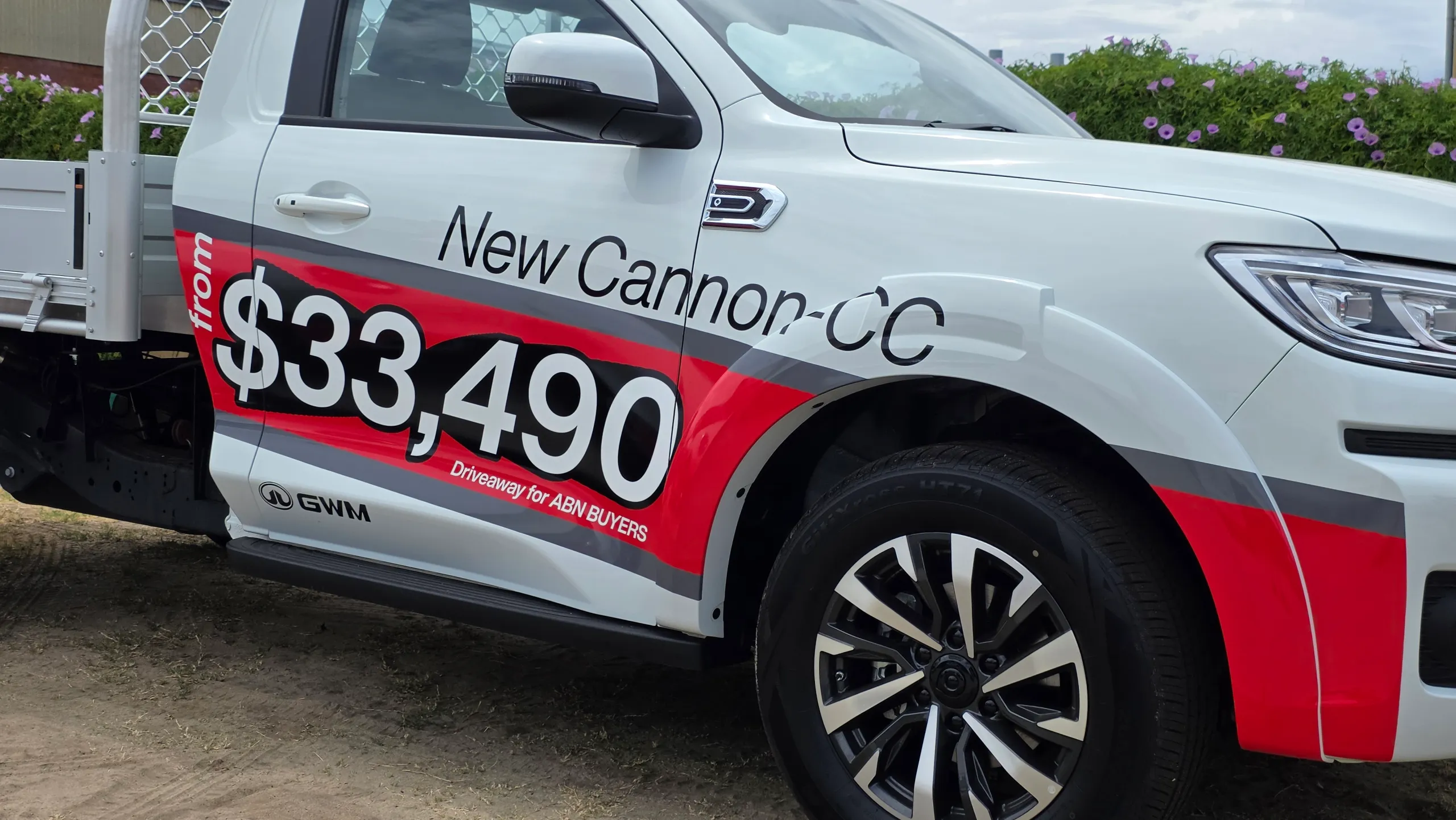 Promotional graphics on the white GWM Cannon single-cab ute door and front guard