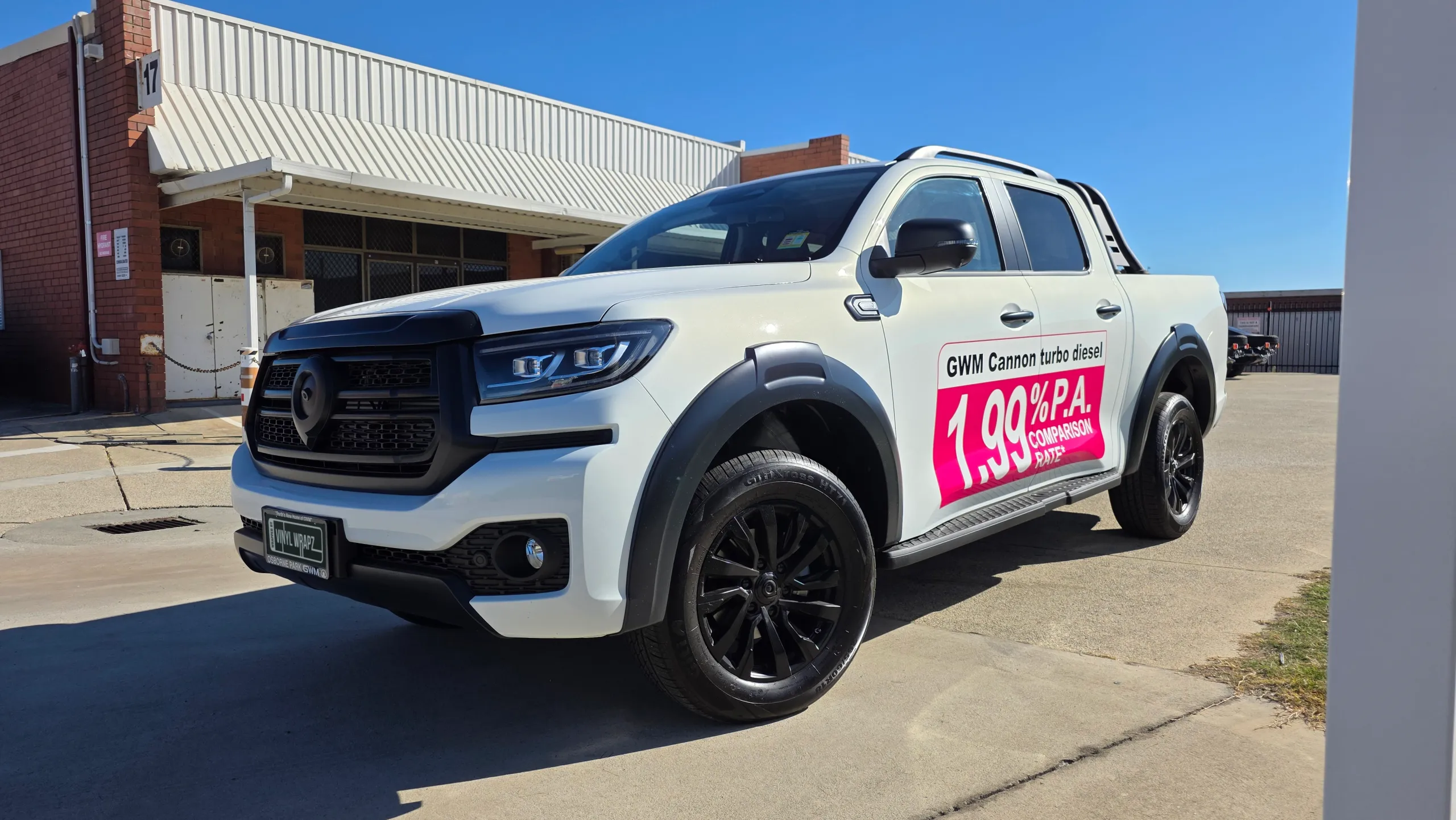 White GWM Cannon dual-cab ute with a promotional panel on its front door