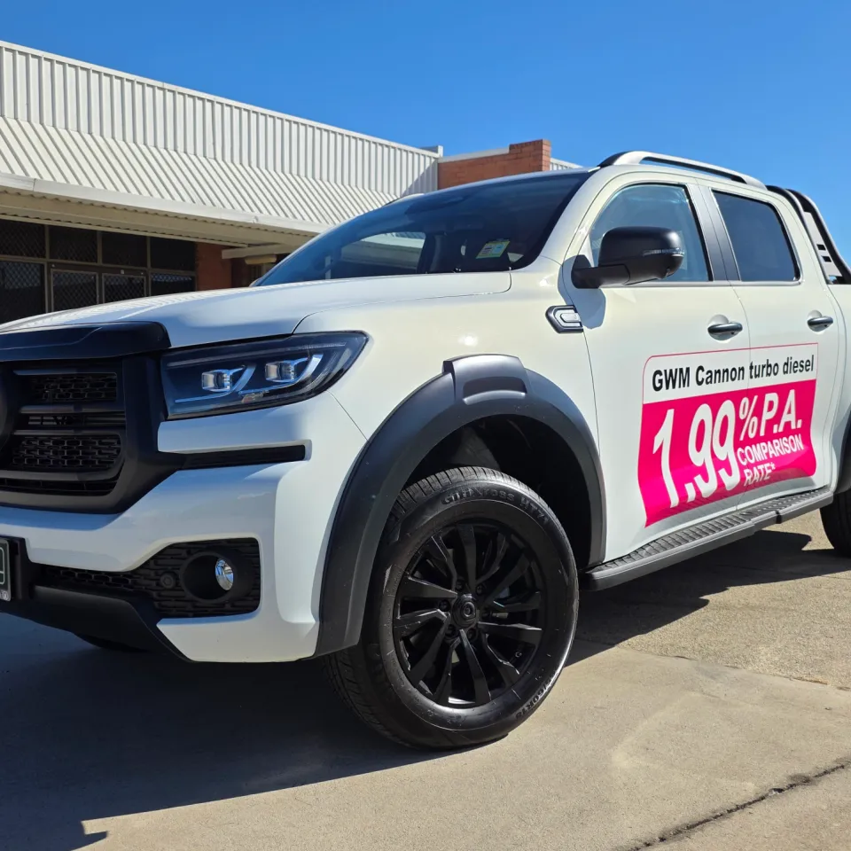 White GWM Cannon dual-cab ute with a promotional panel on its front door