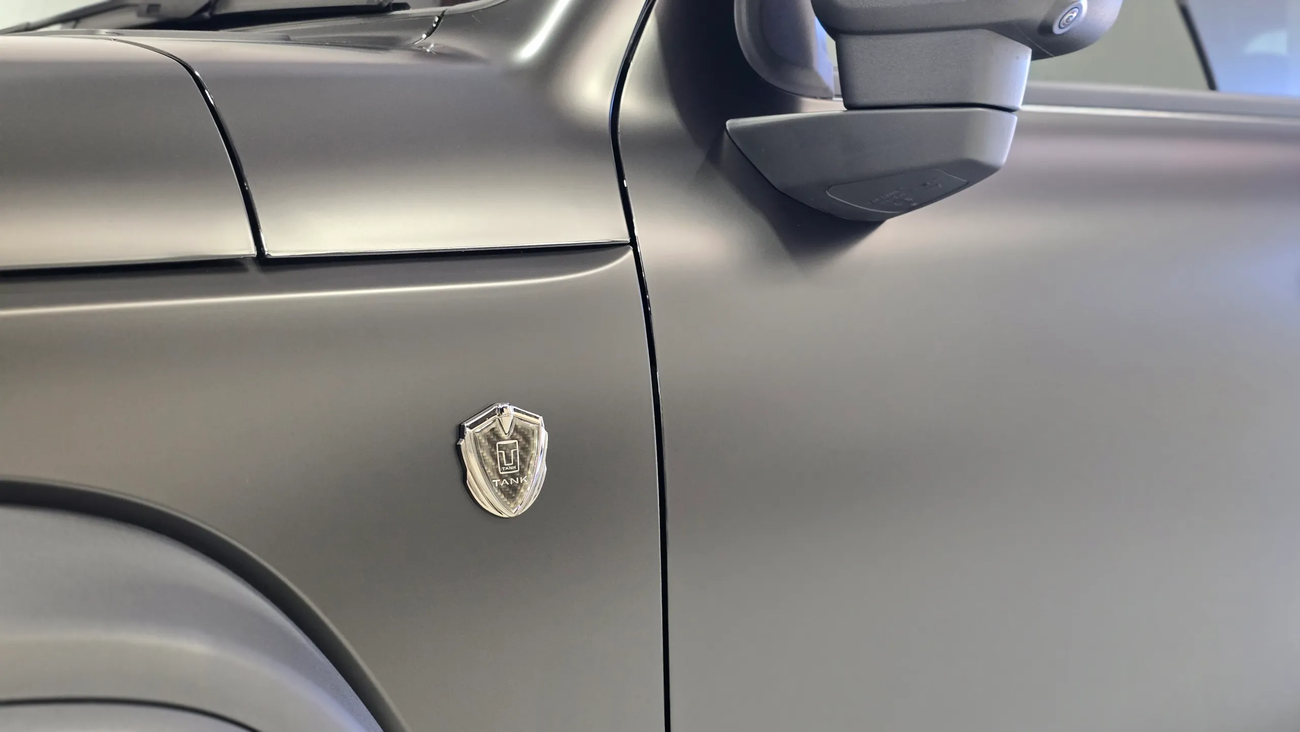Tank emblem on the satin black front guard of a GWM Tank 300, beside the door and mirror