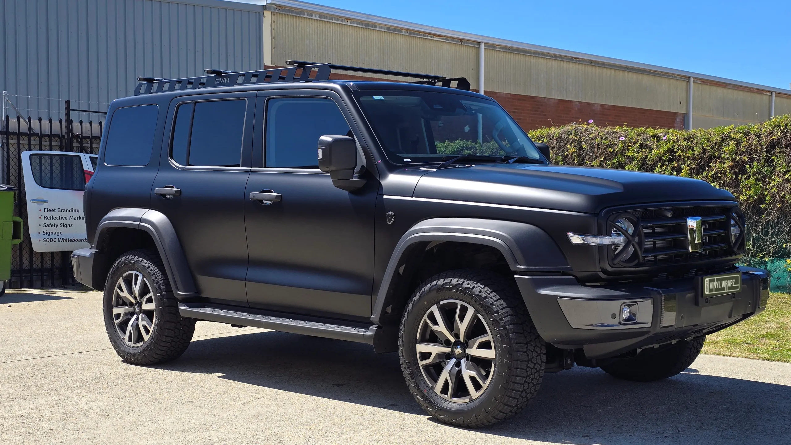 Satin black GWM Tank 300 viewed from the front quarter outside the workshop