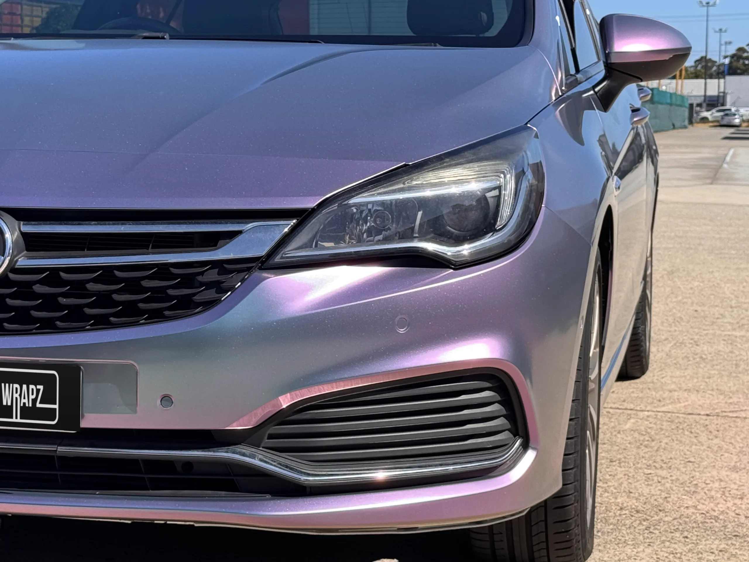 Lavender colour-shift Holden Astra hatchback outside the workshop, front detail