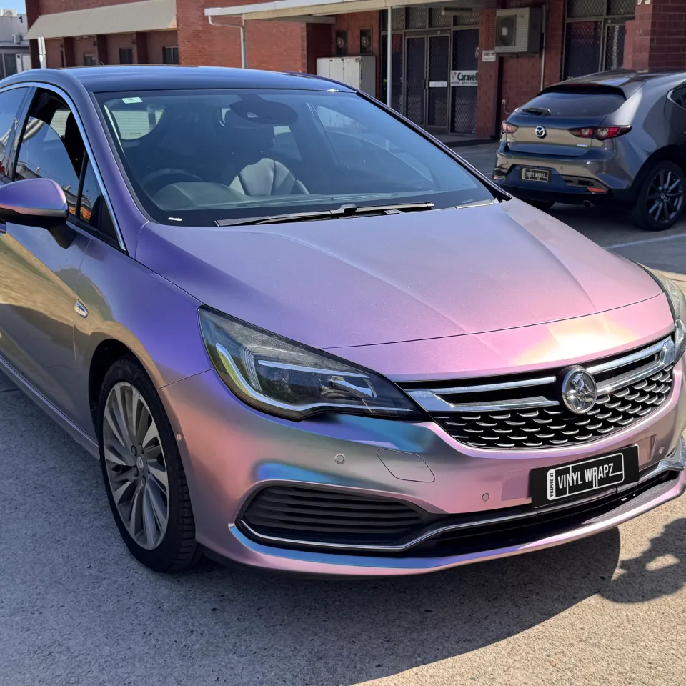 Lavender colour-shift Holden Astra hatchback outside the workshop, front quarter