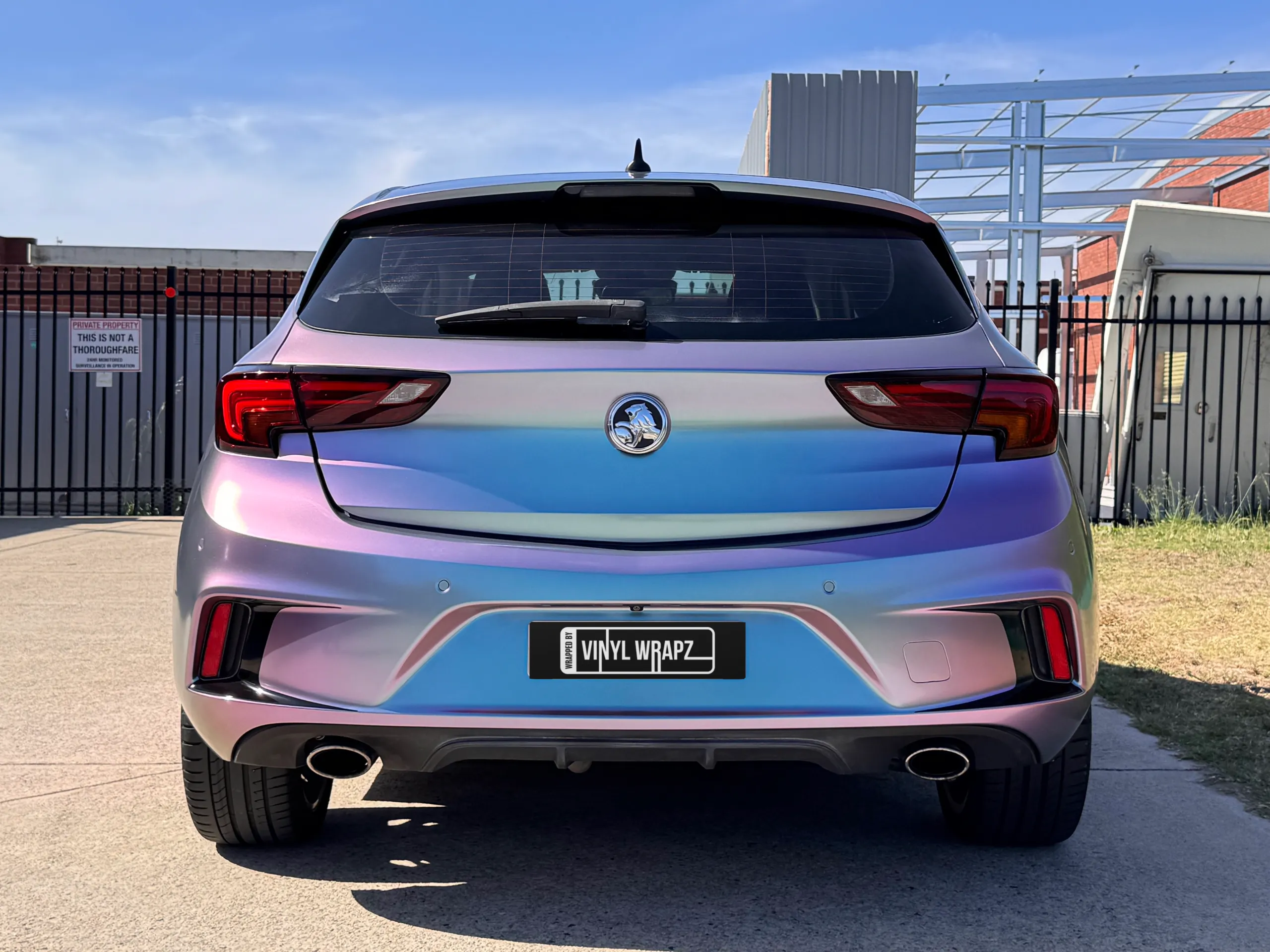 Lavender colour-shift Holden Astra hatchback outside the workshop, rear