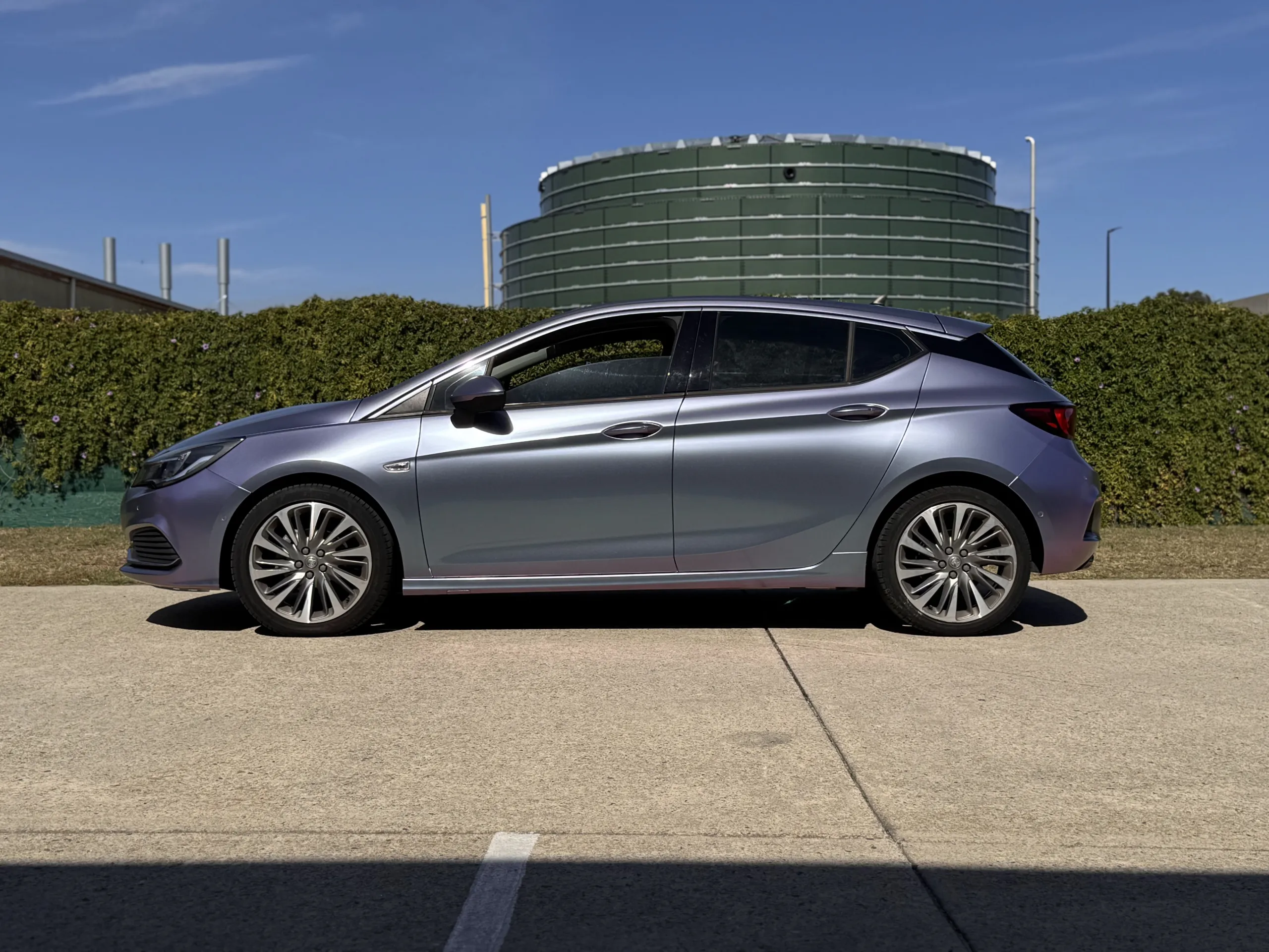 Lavender colour-shift Holden Astra hatchback outside the workshop, side
