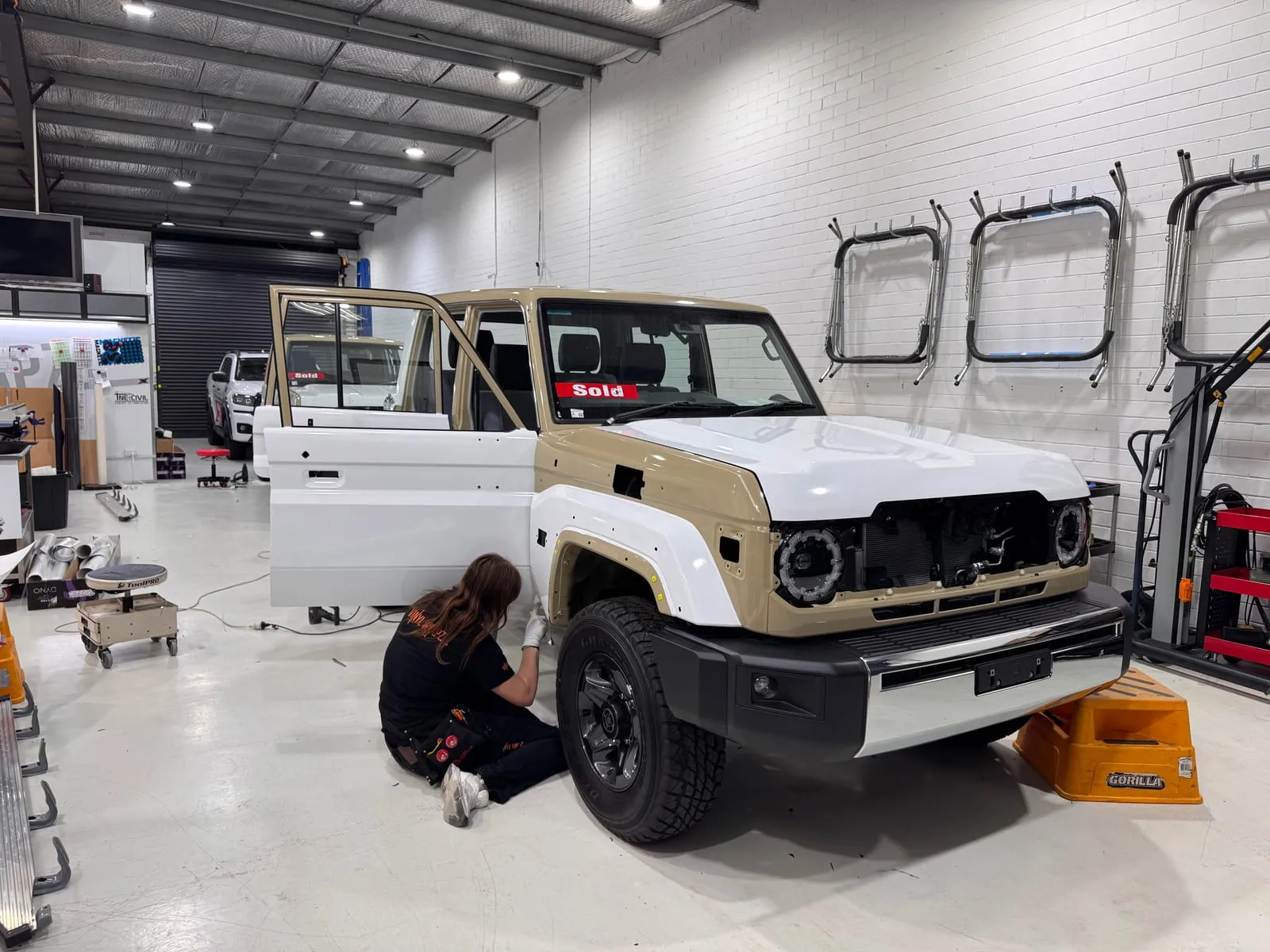 Installer prepping a Land Cruiser Troop Carrier for a white colour change wrap
