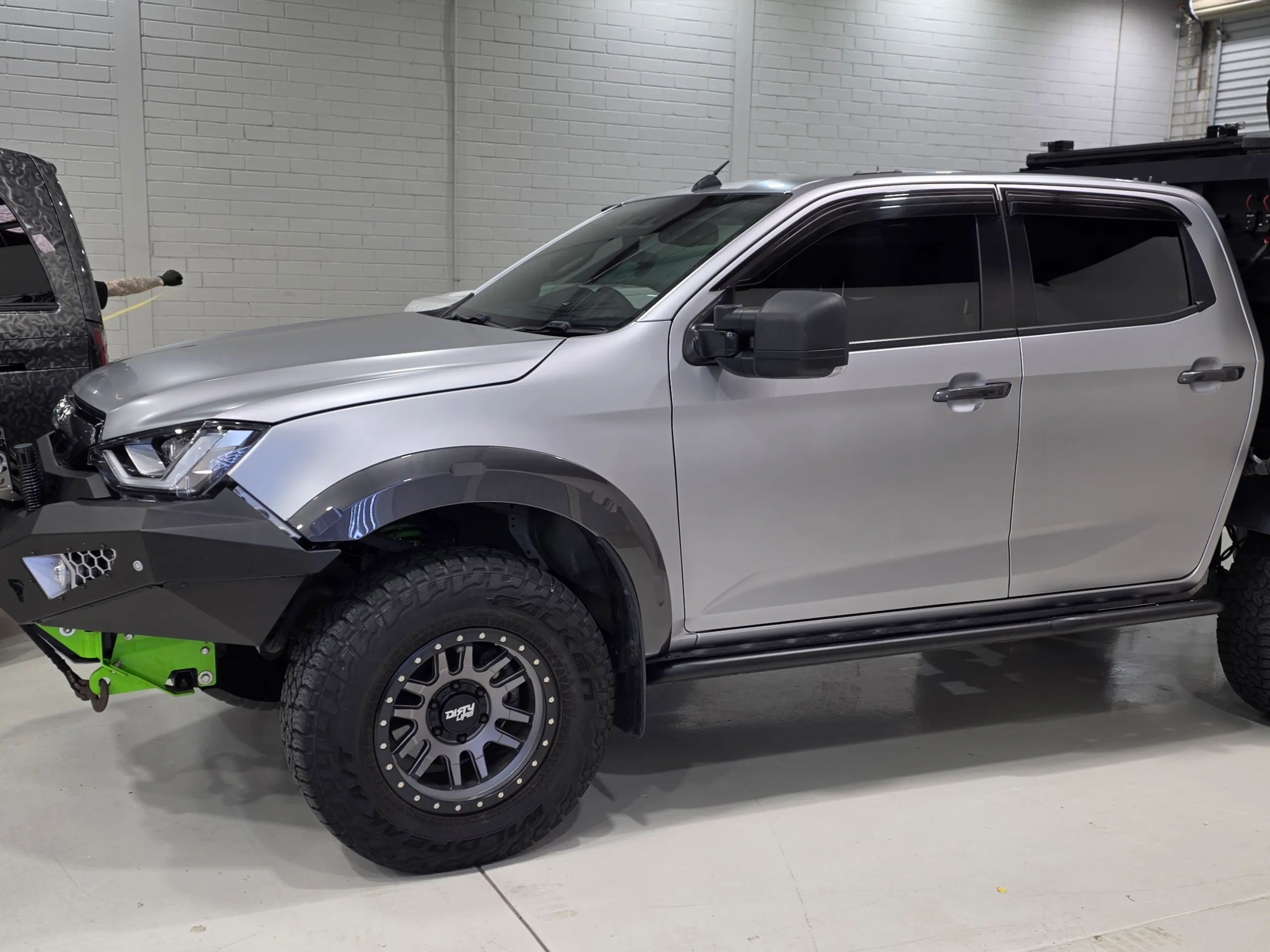 Side view of the satin silver Isuzu D-MAX cab and black wheel-arch trim