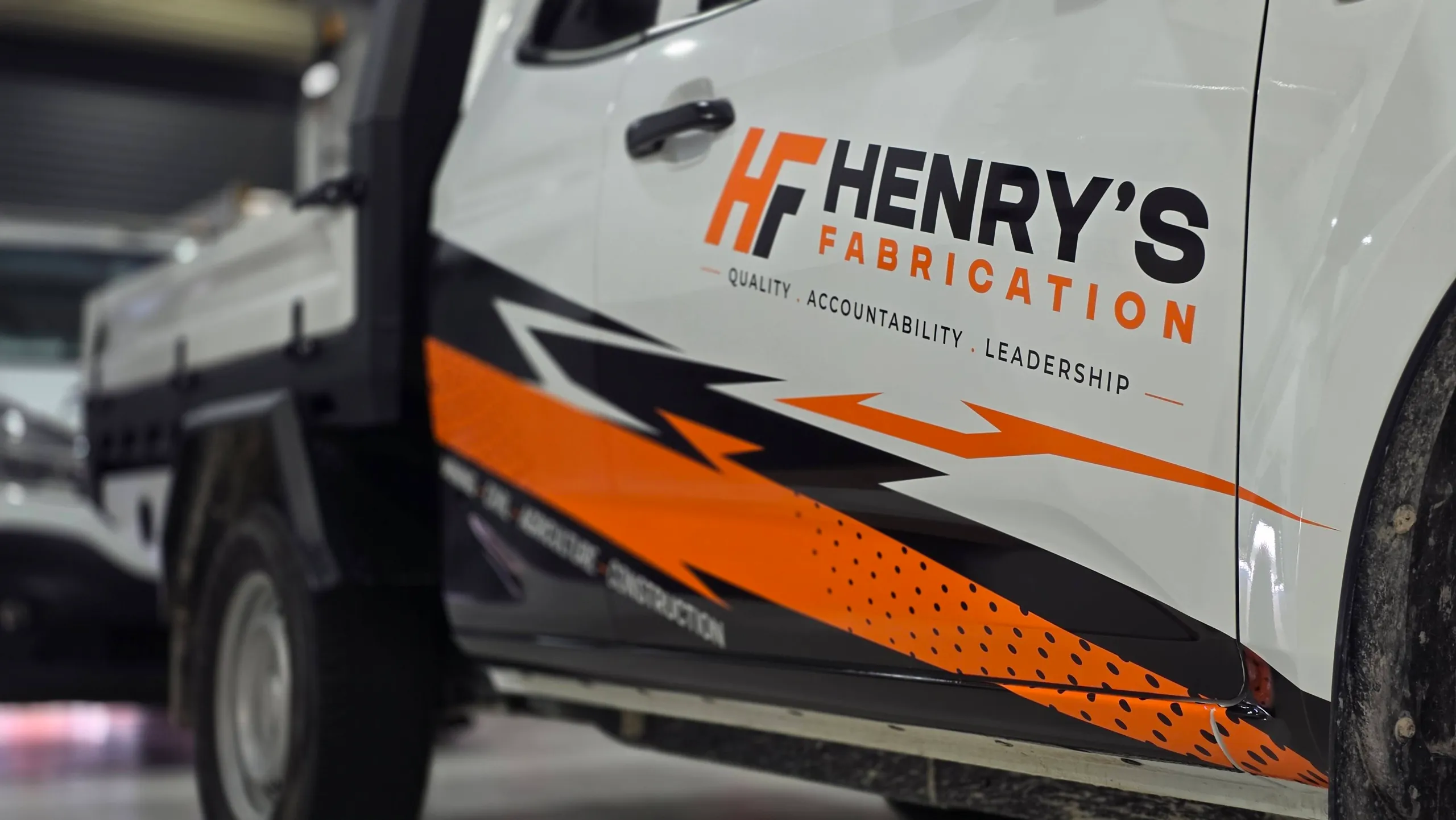 HF logo and angular orange and black graphics across the Isuzu ute doors