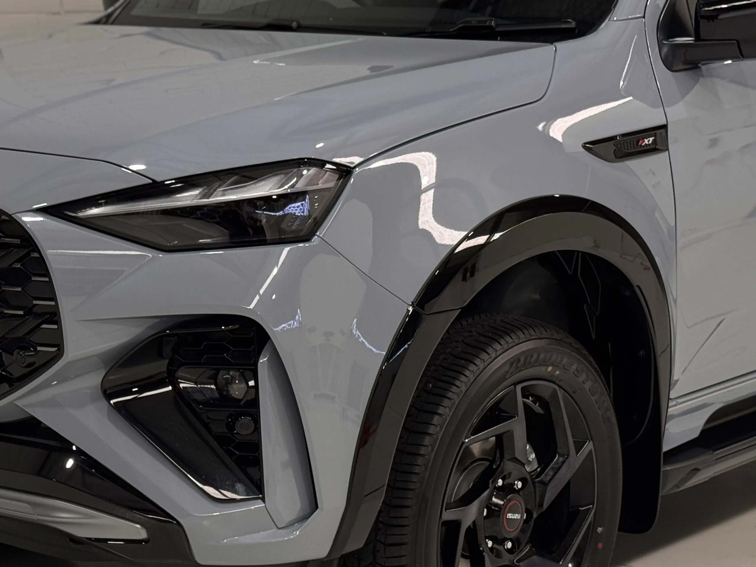 Grey Isuzu MU-X front wheel, guard and headlight in the workshop
