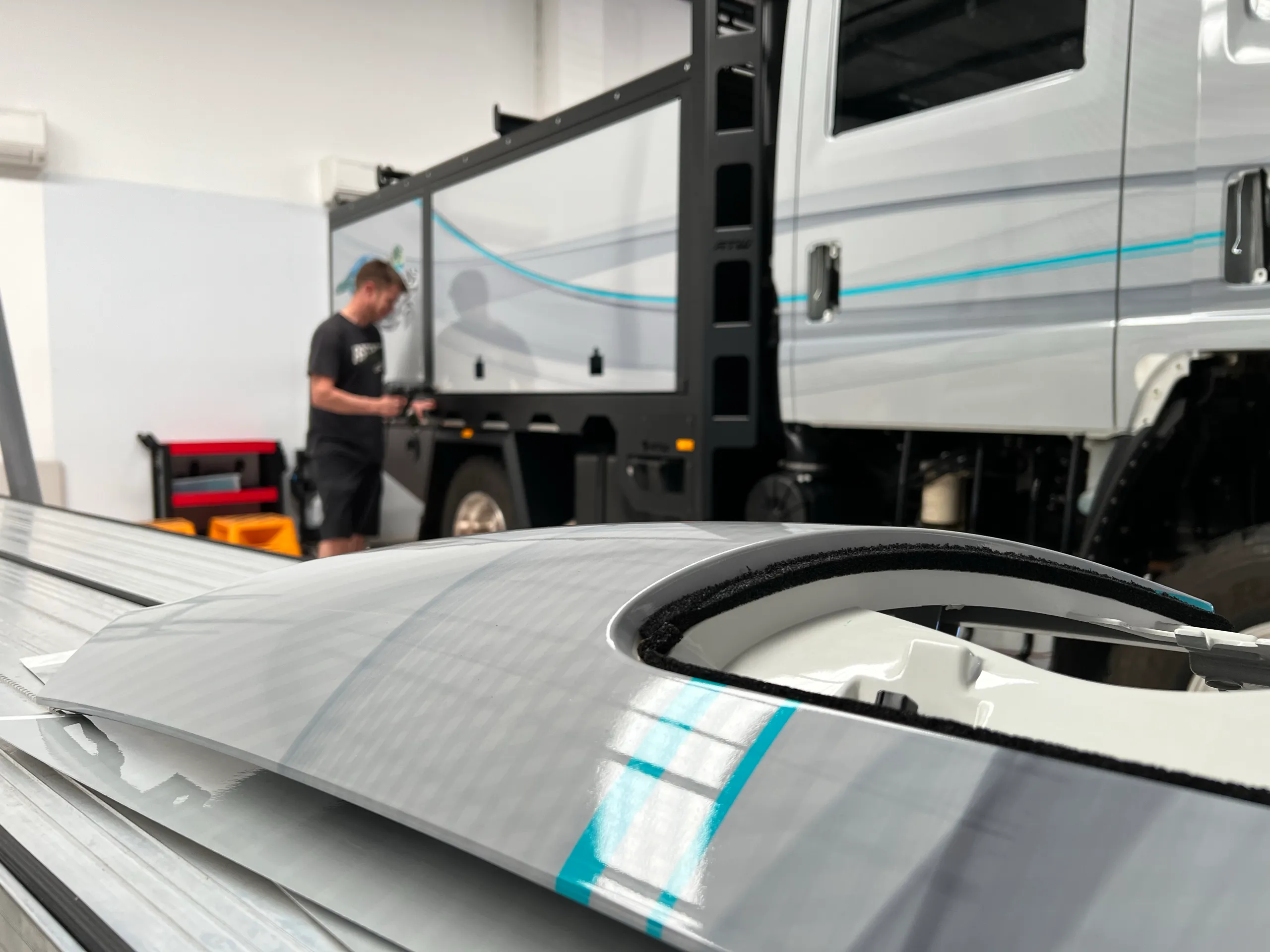 Grey film being fitted to a cab panel on the bench