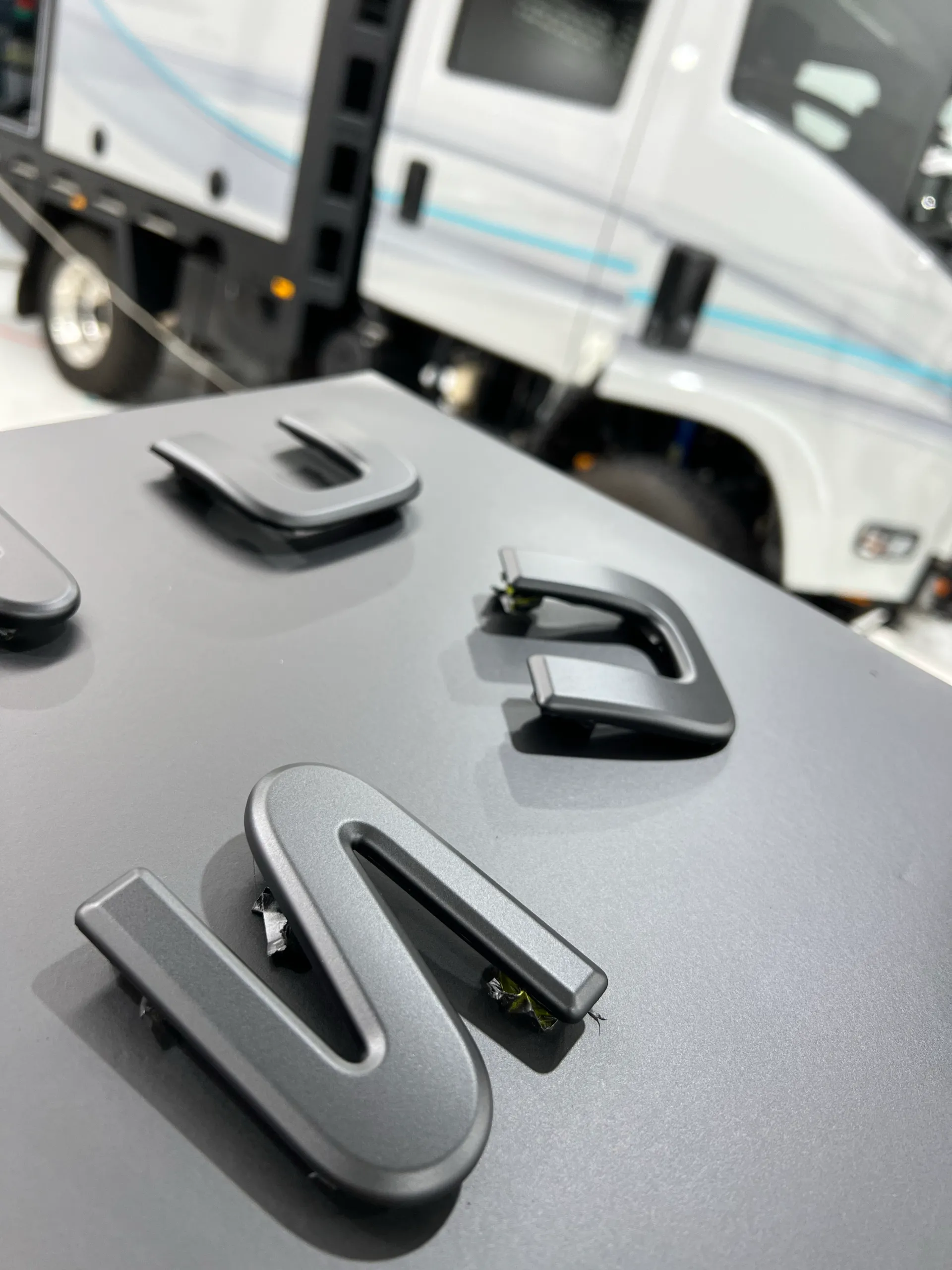 Removed vehicle badges laid out beside the camper truck