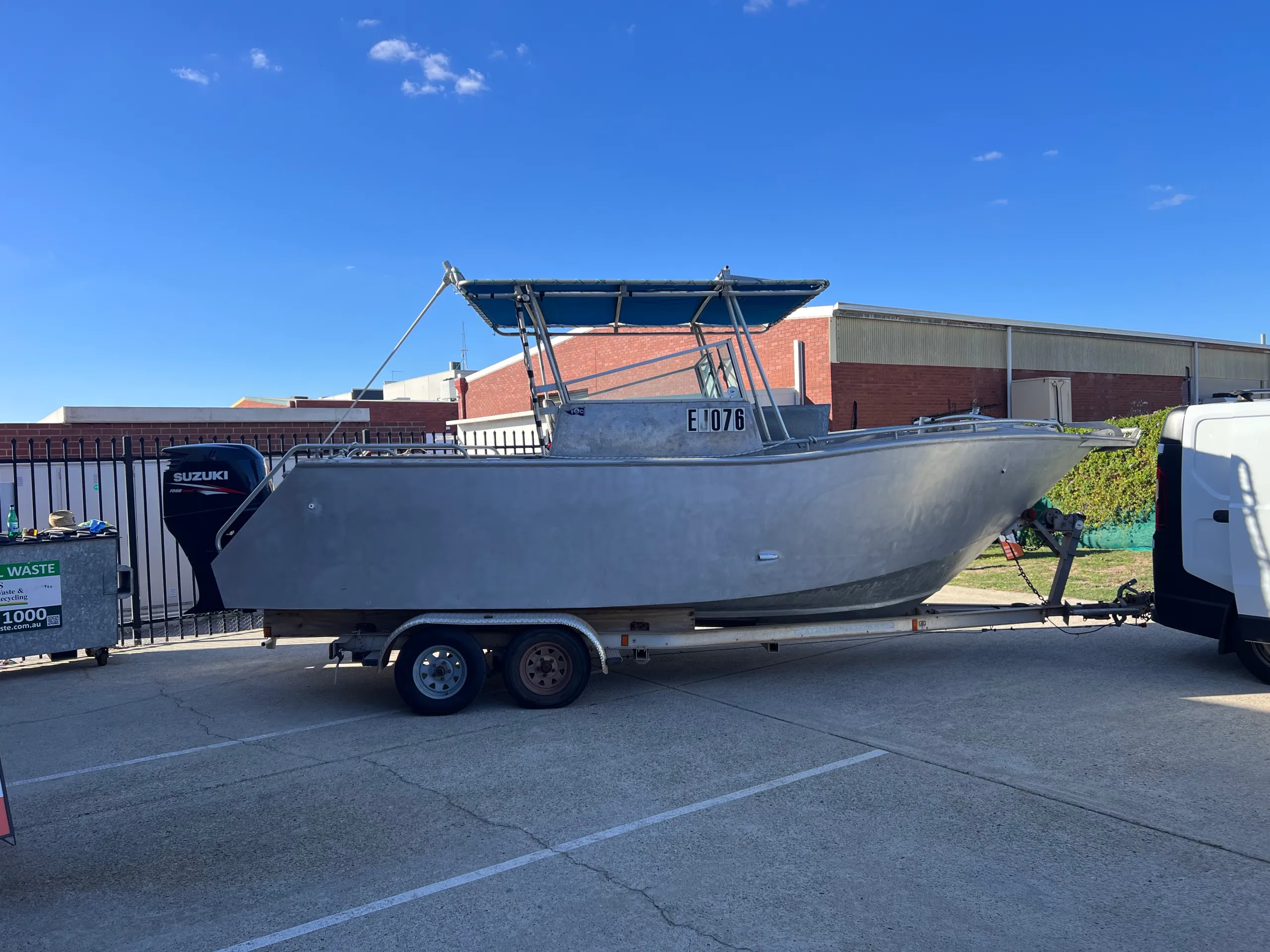 Bare aluminium boat on its trailer outside the workshop before graphics were applied