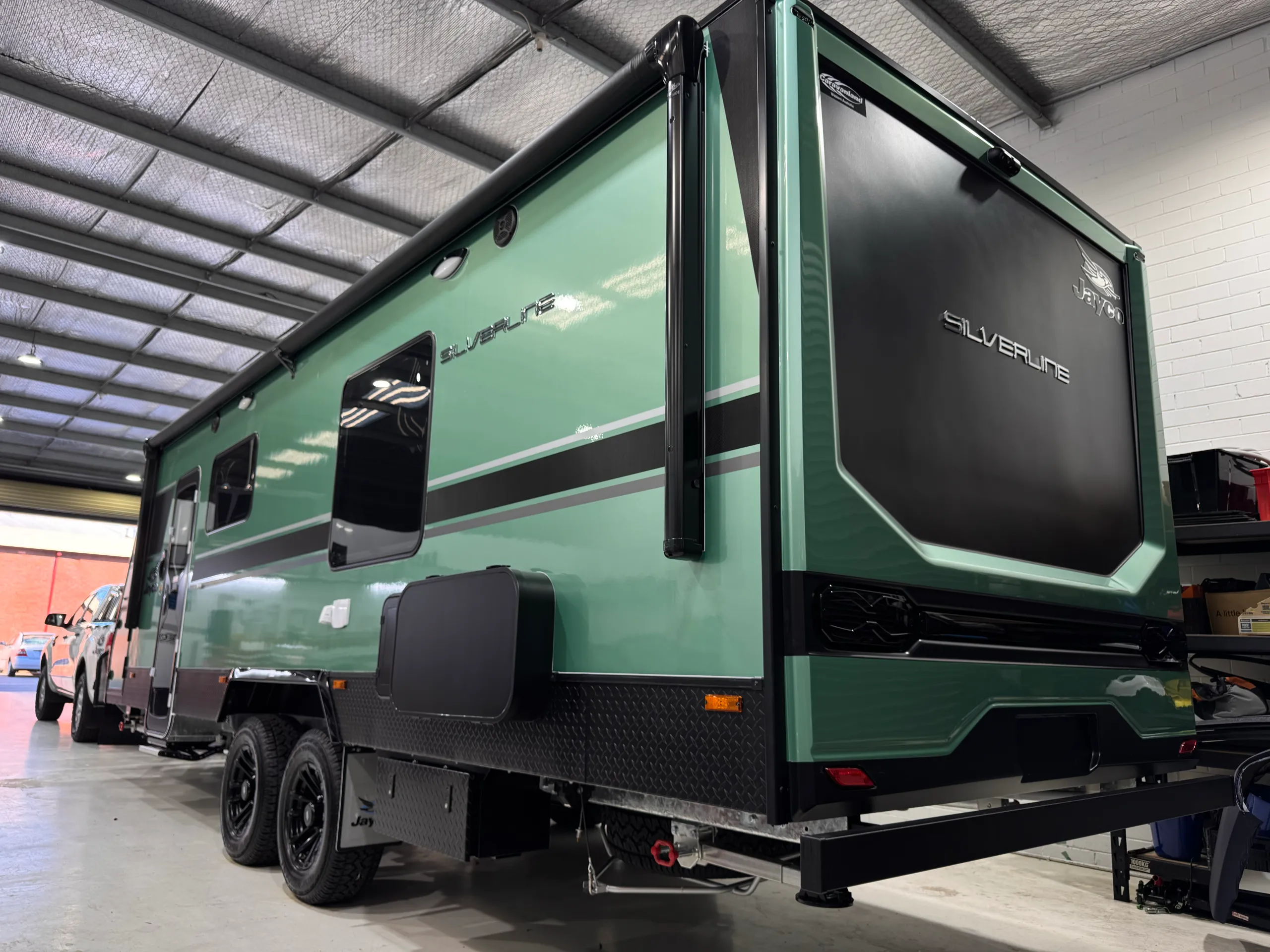 Green Jayco Silverline caravan viewed from the rear quarter in the workshop