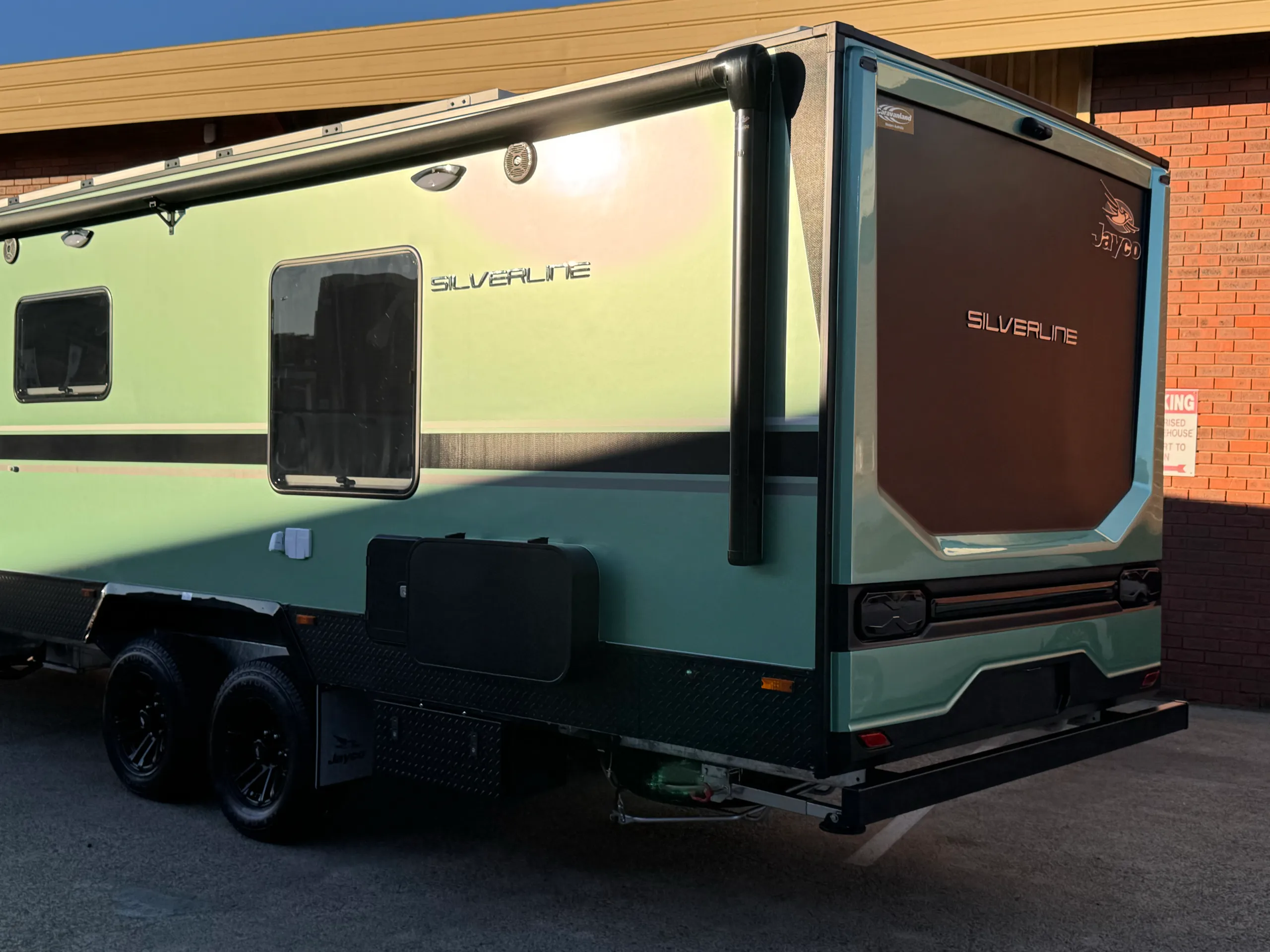 Green Jayco Silverline caravan in warm sunlight, viewed from the rear quarter