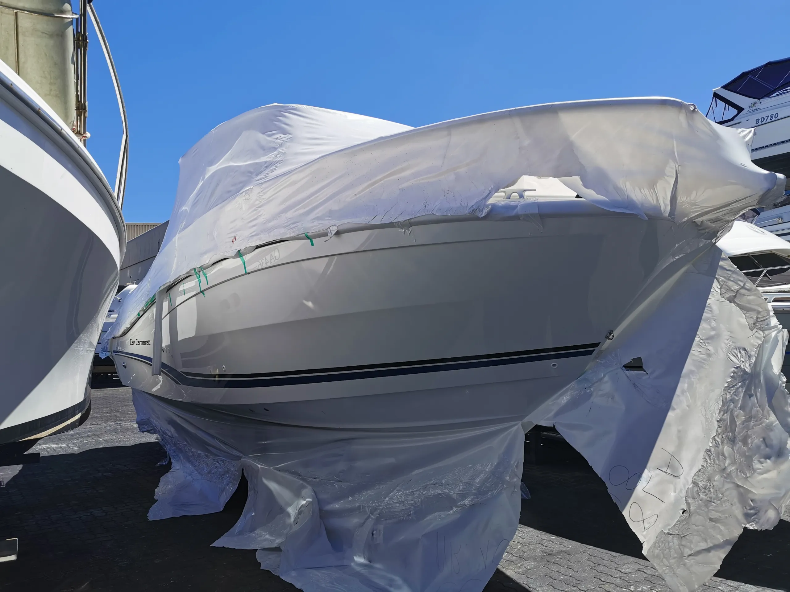 White Cap Camarat boat partly covered in protective plastic at a boat storage yard