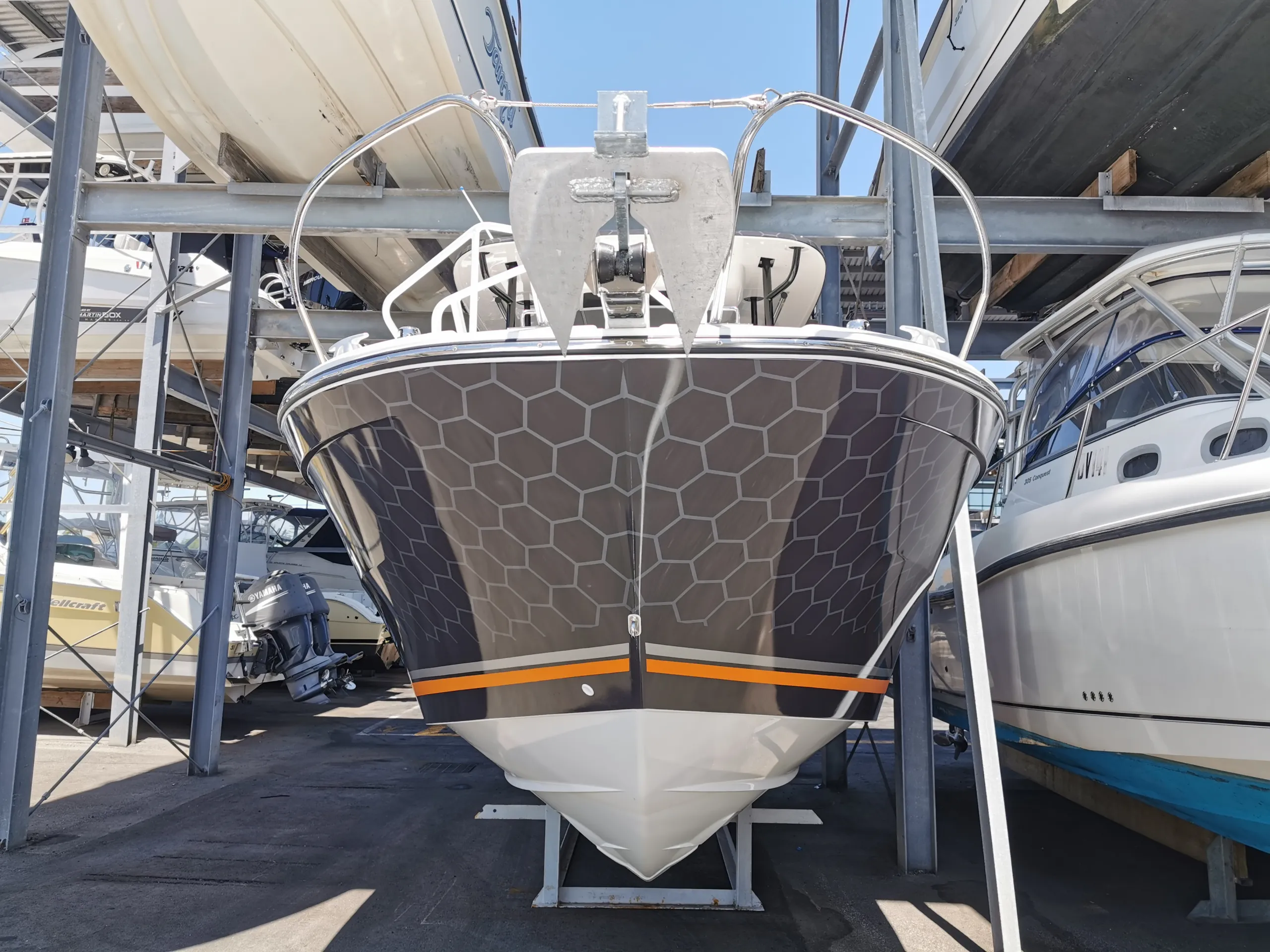 Head-on view of the Cap Camarat bow with honeycomb graphics and an orange stripe