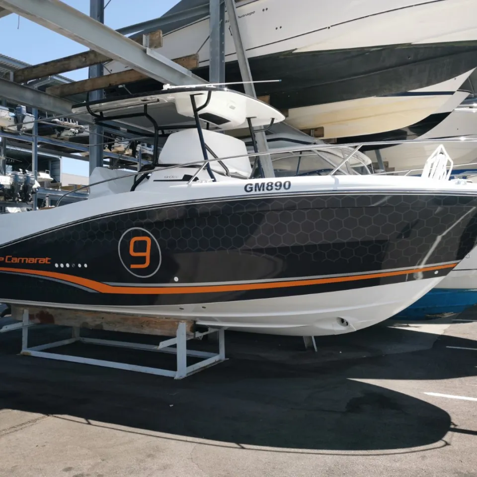 Jeanneau Cap Camarat 9 with charcoal honeycomb graphics and orange accents at the boat yard