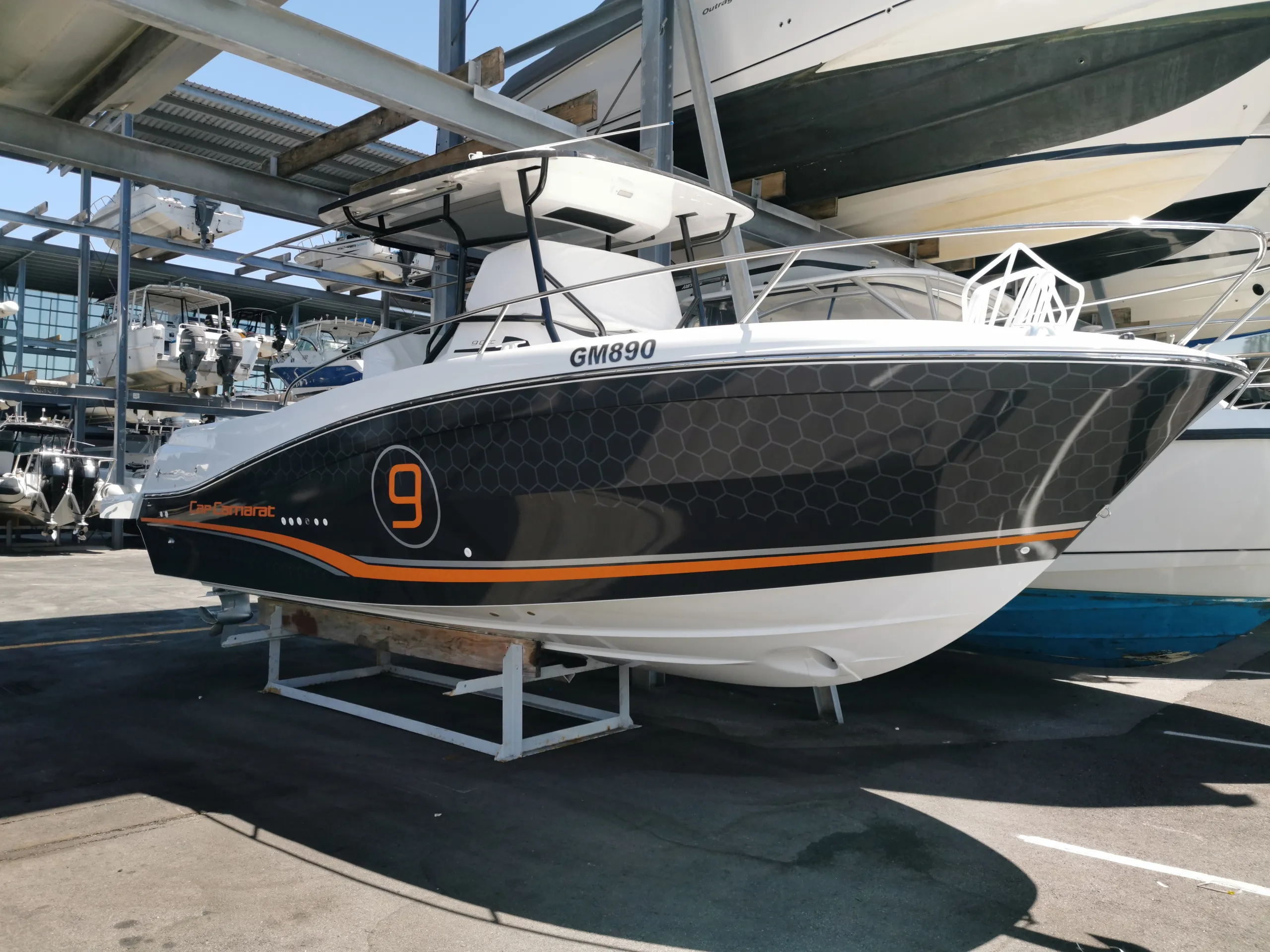 Side-quarter view of the finished Cap Camarat graphics, orange stripe and number 9