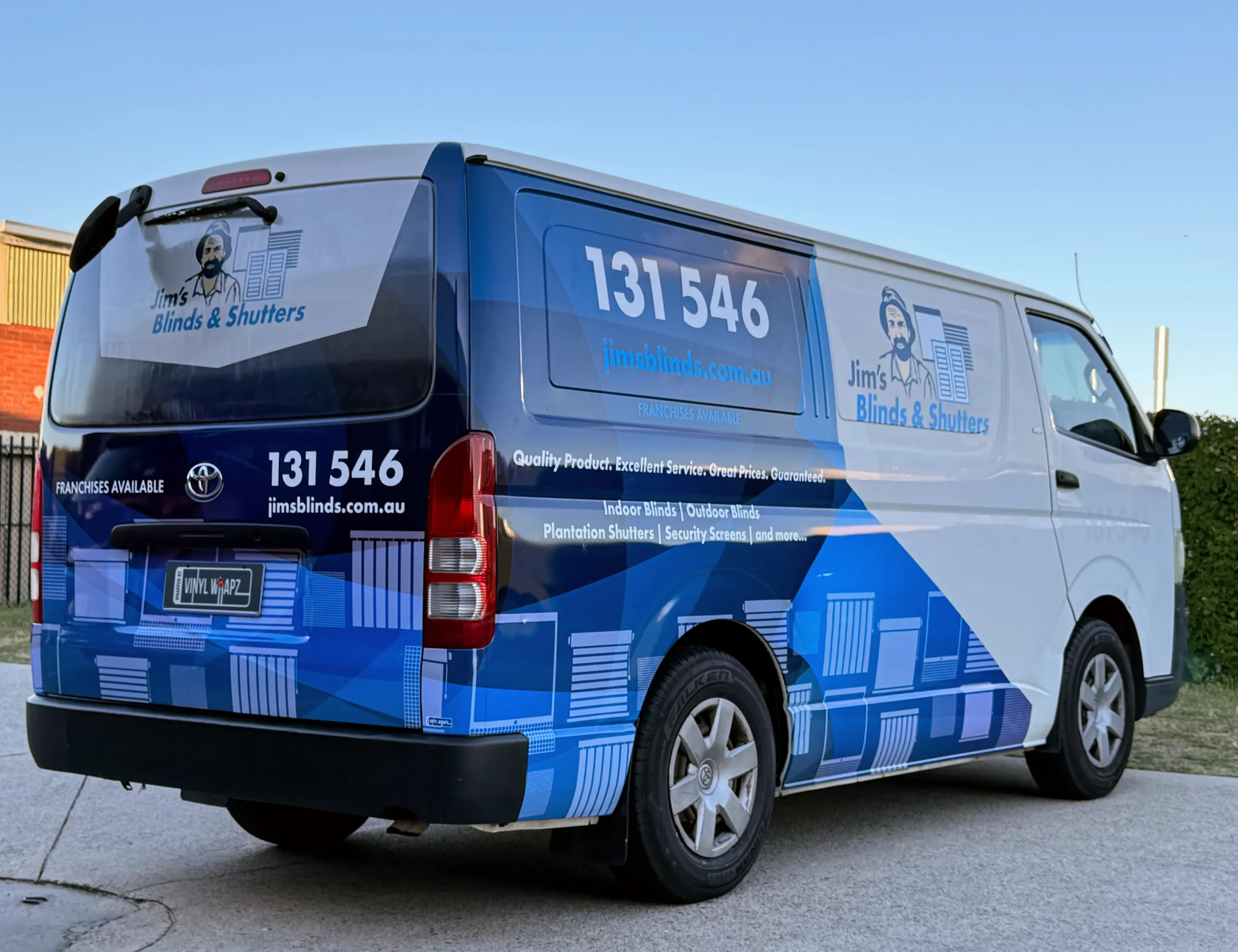 Jim's Blinds & Shutters blue and white graphics on a Toyota HiAce, viewed from the rear quarter