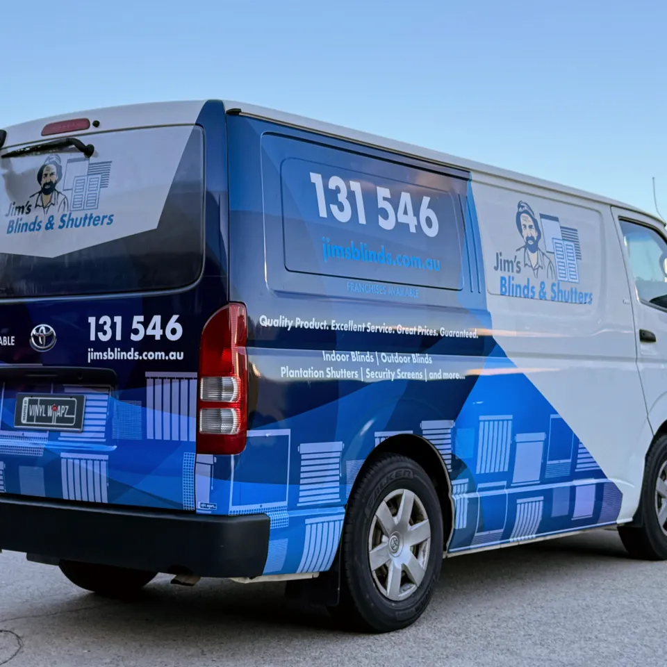 Jim's Blinds & Shutters blue and white graphics on a Toyota HiAce, viewed from the rear quarter