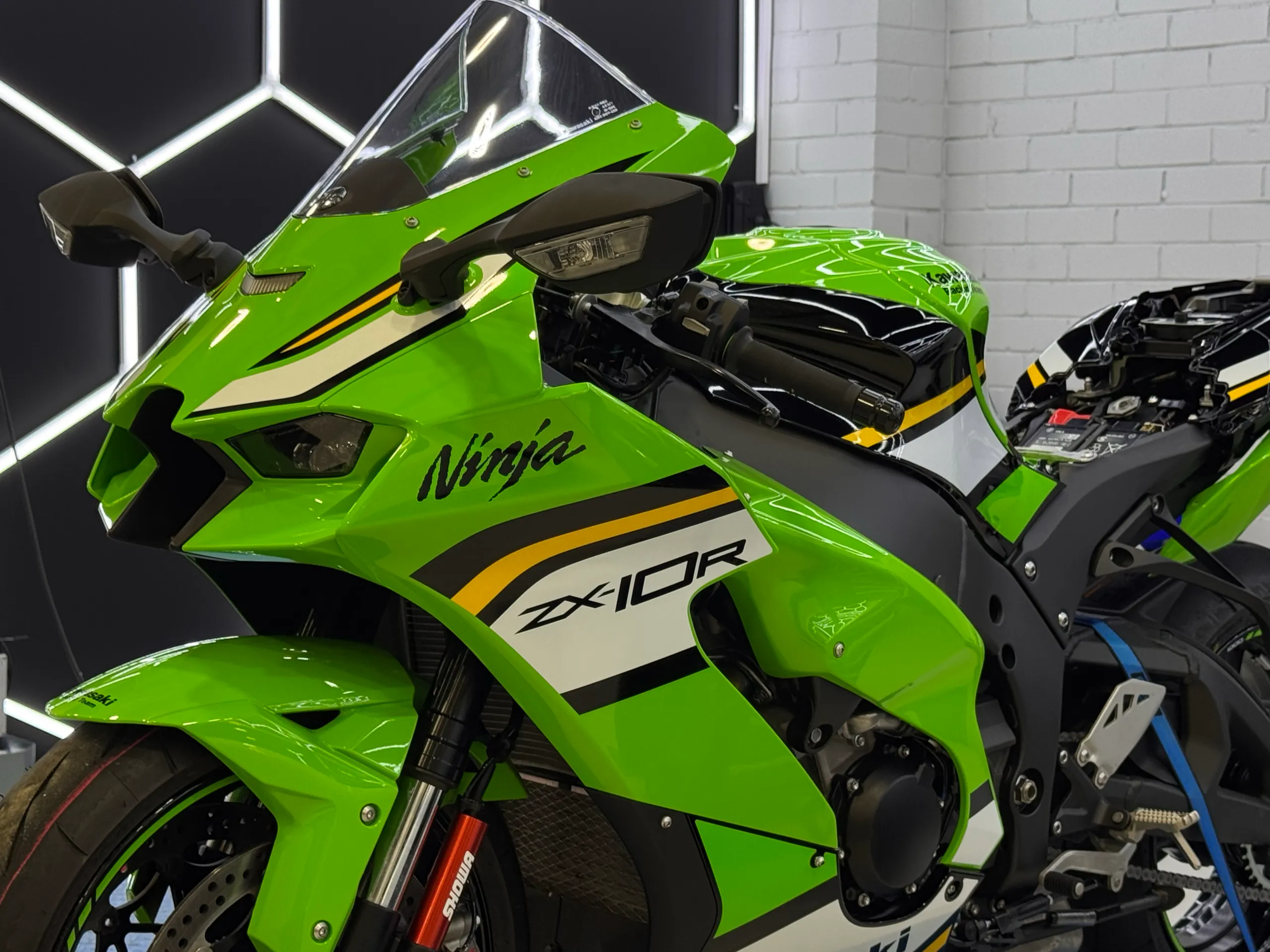 Green Kawasaki Ninja ZX-10R front fairing in the workshop with its seat removed