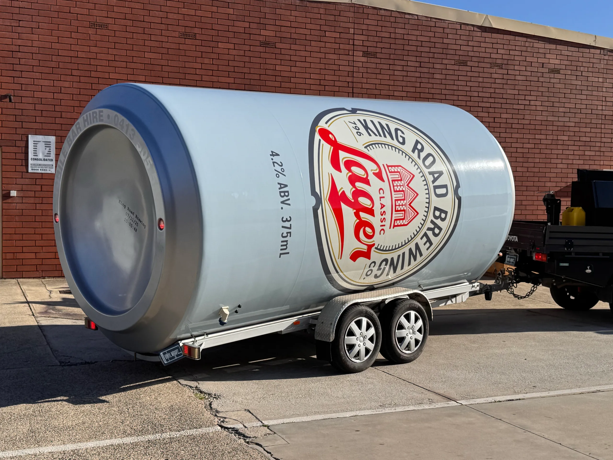 Rear-quarter view of the King Road can trailer attached to a ute outdoors