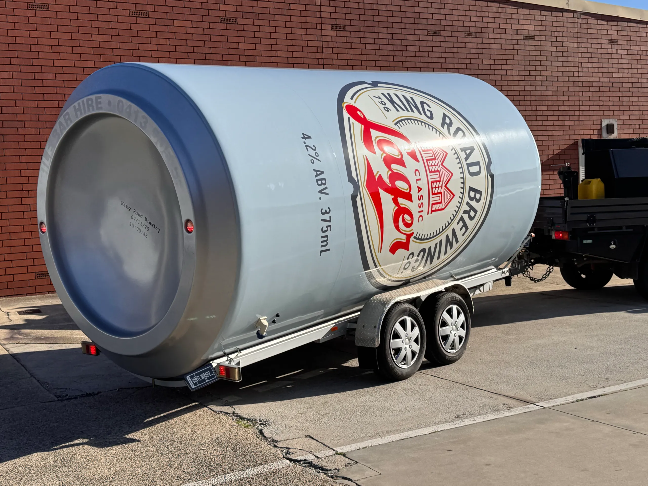 Silver can base and pale blue branding at the rear of the King Road Lager trailer