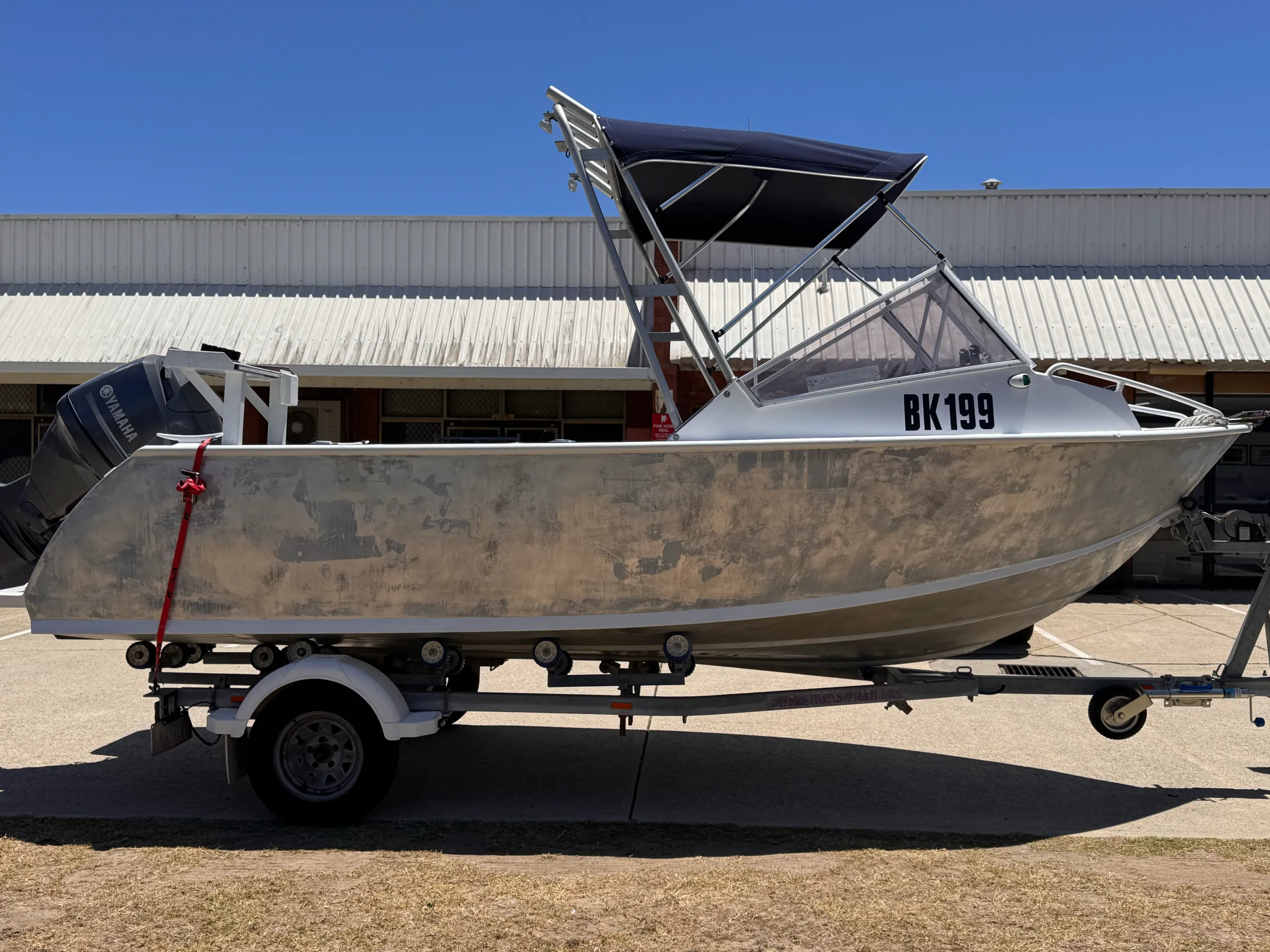 Bare aluminium hull viewed from the bow quarter on its trailer