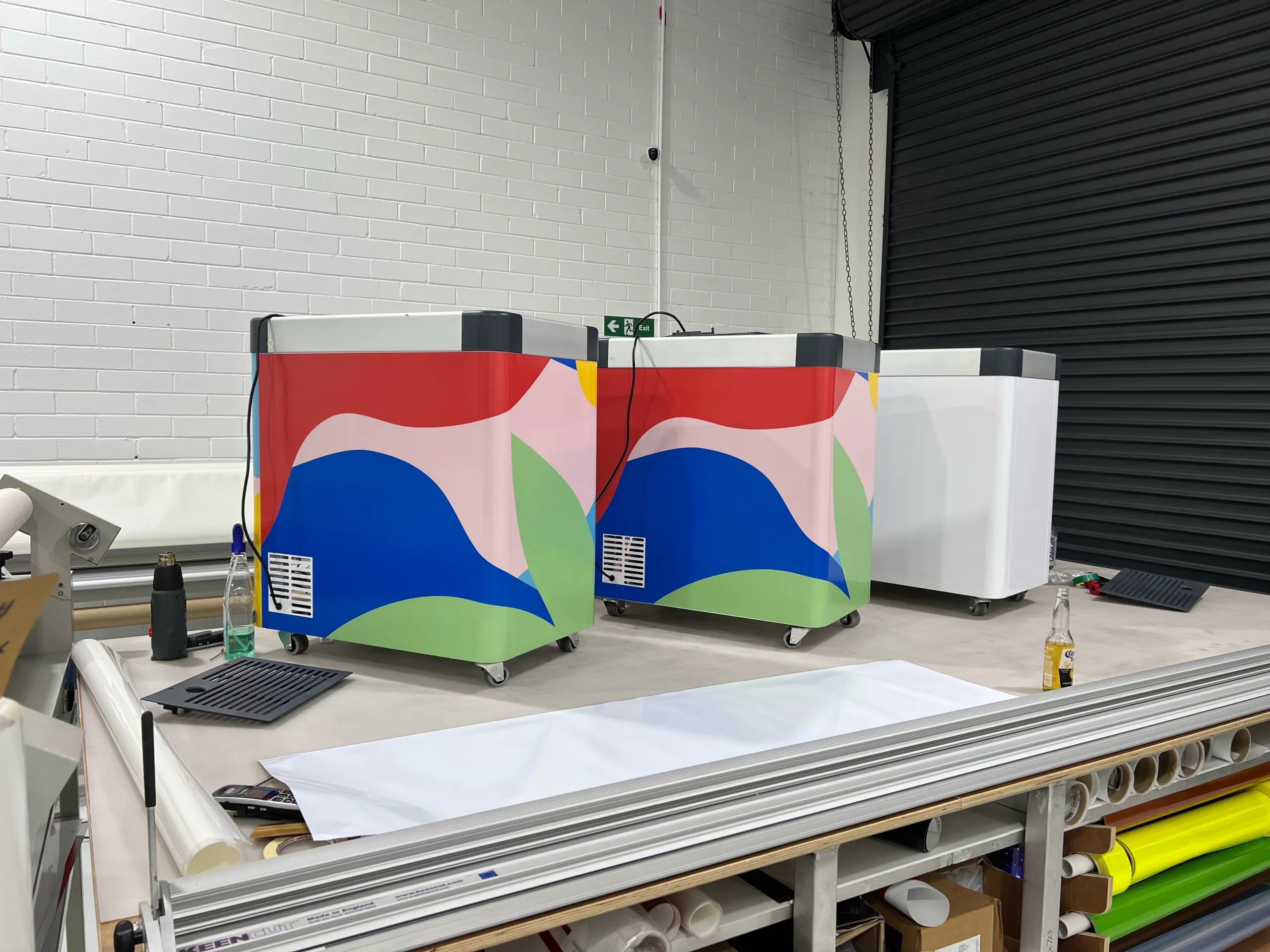 Wrapped freezer panels and bright graphics on a workshop bench