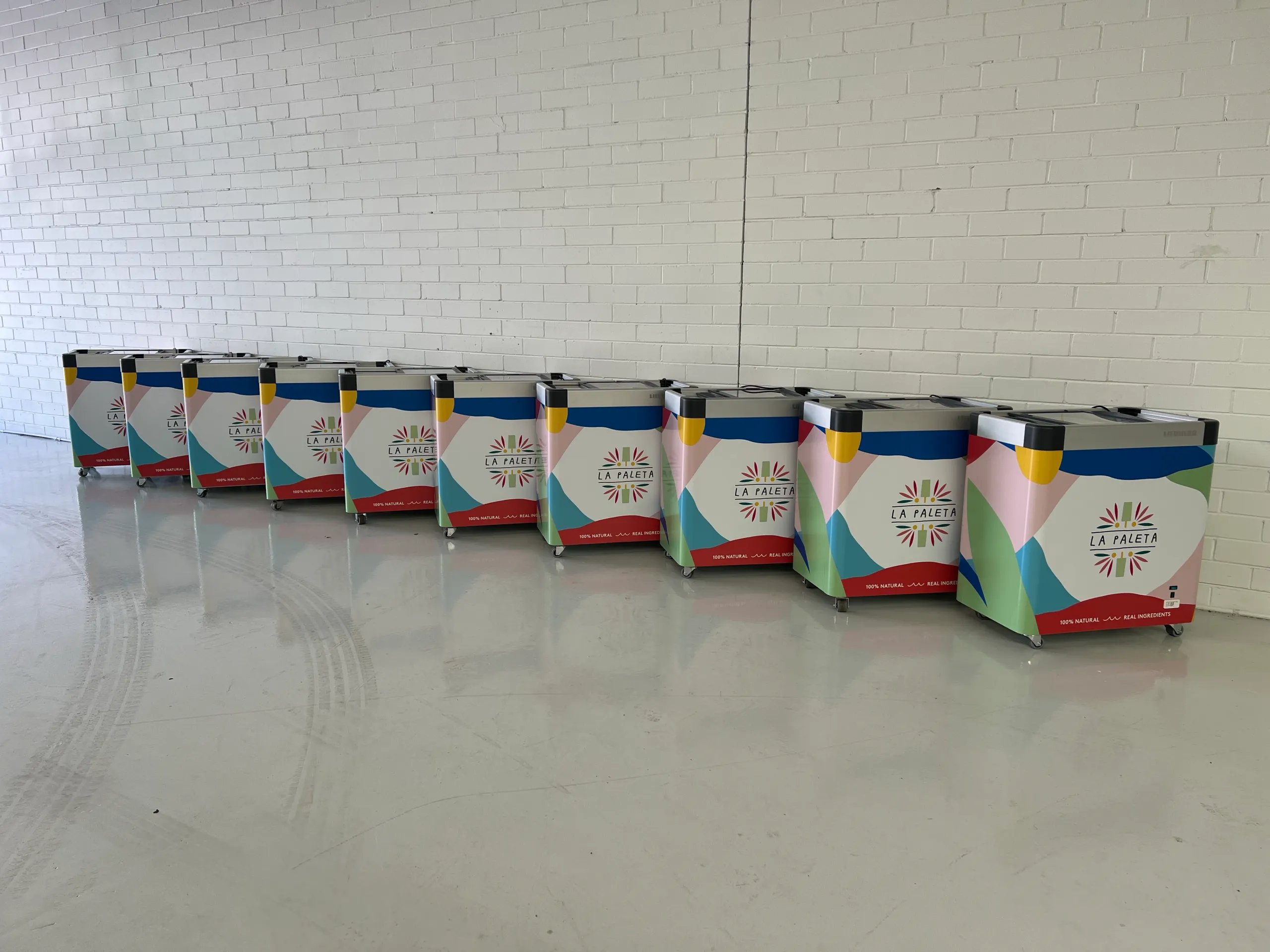 Row of completed La Paleta branded ice cream freezers