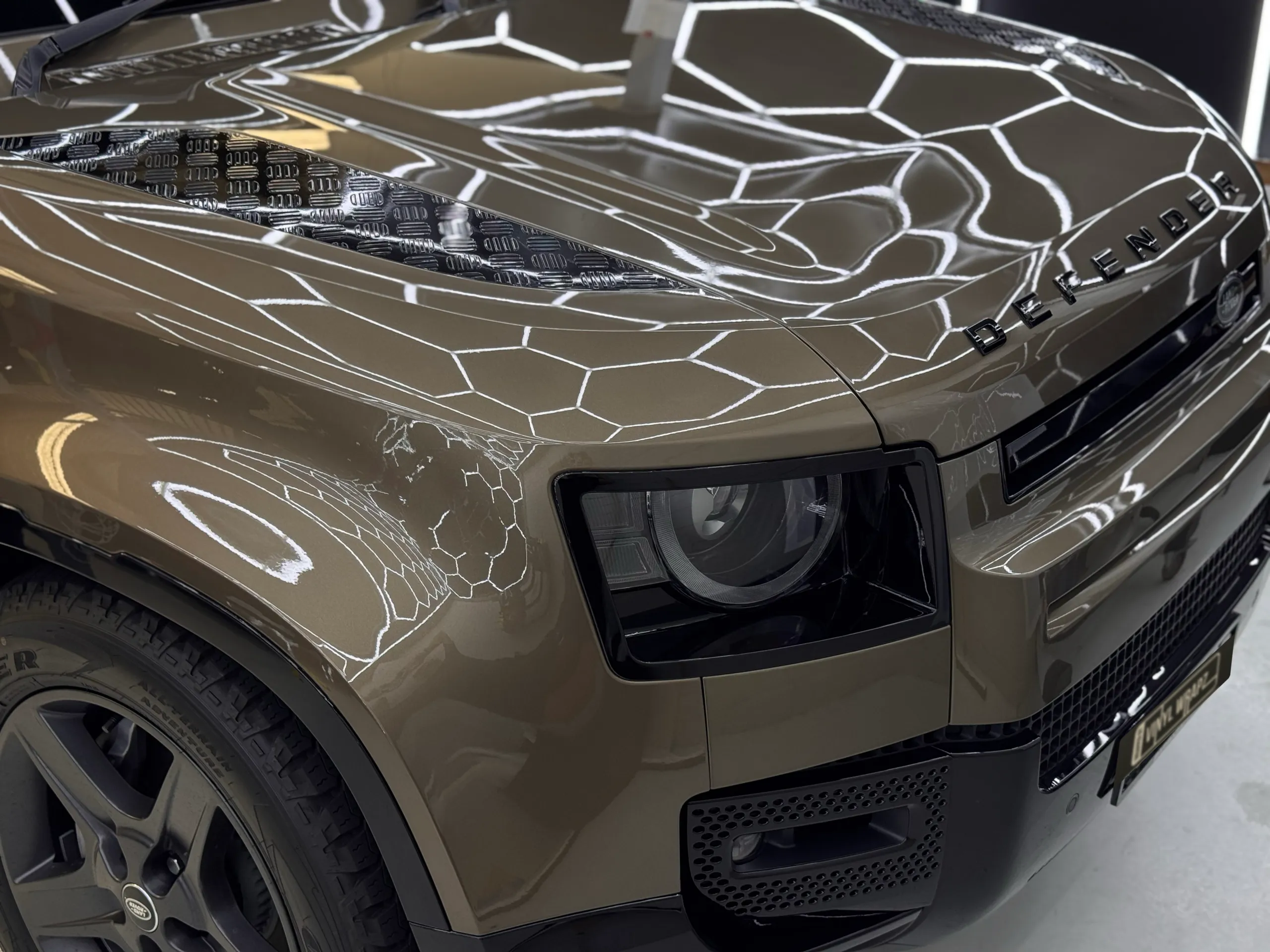 Land Rover Defender bonnet lettering, headlight and gloss bronze front bodywork in the workshop