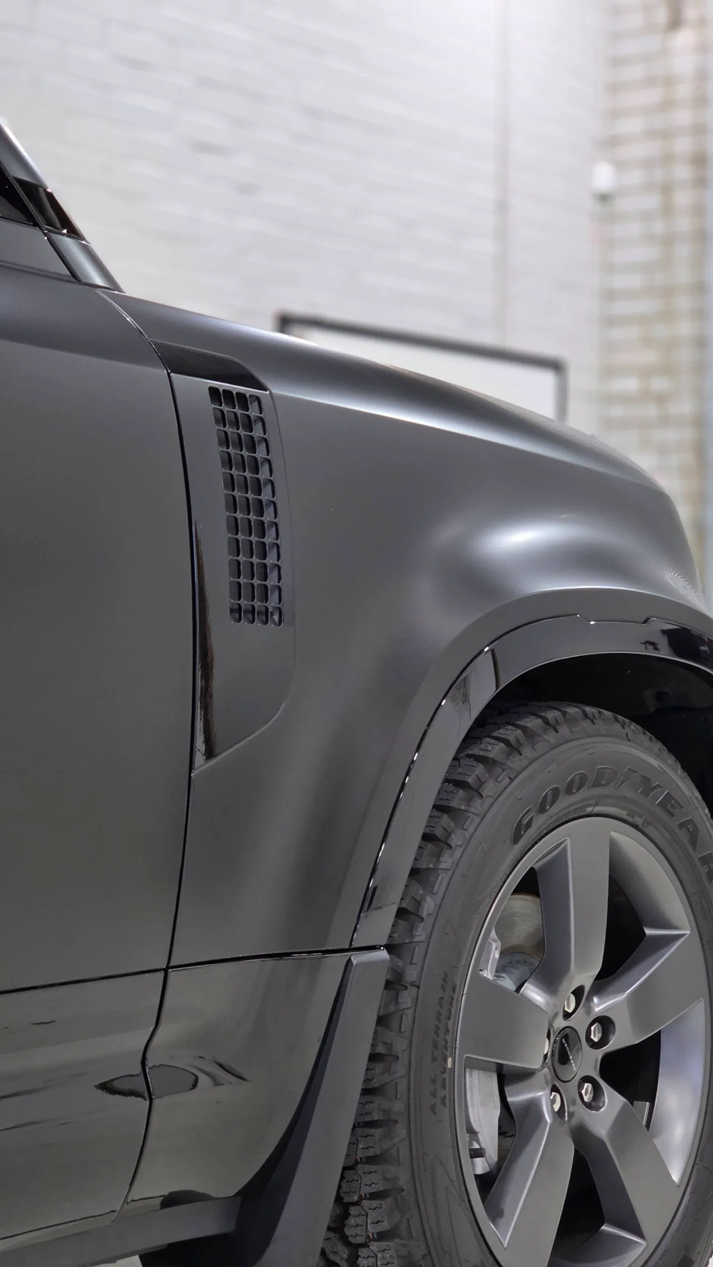 Matte dark grey Land Rover Defender front guard, vent and wheel with gloss black arch trim