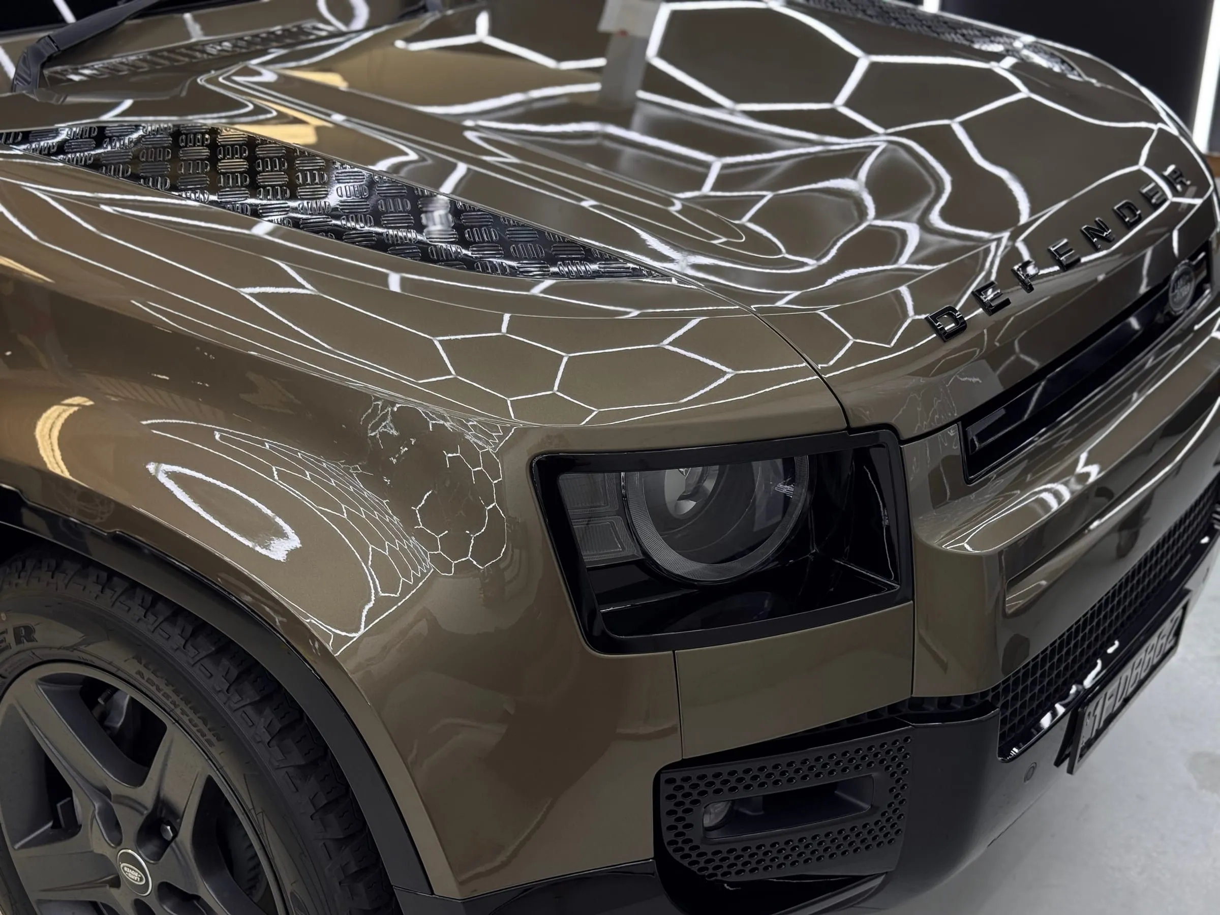 Land Rover Defender bonnet and headlight in gloss paint protection film under the hexagon lights at Vinyl Wrapz, Perth