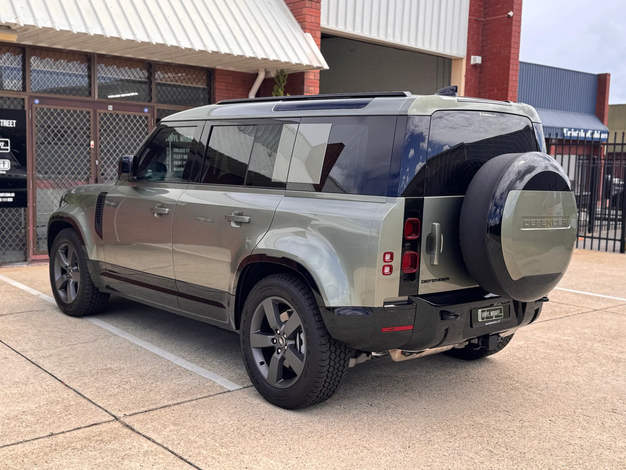Gloss green Defender rear quarter with its spare wheel fitted outdoors