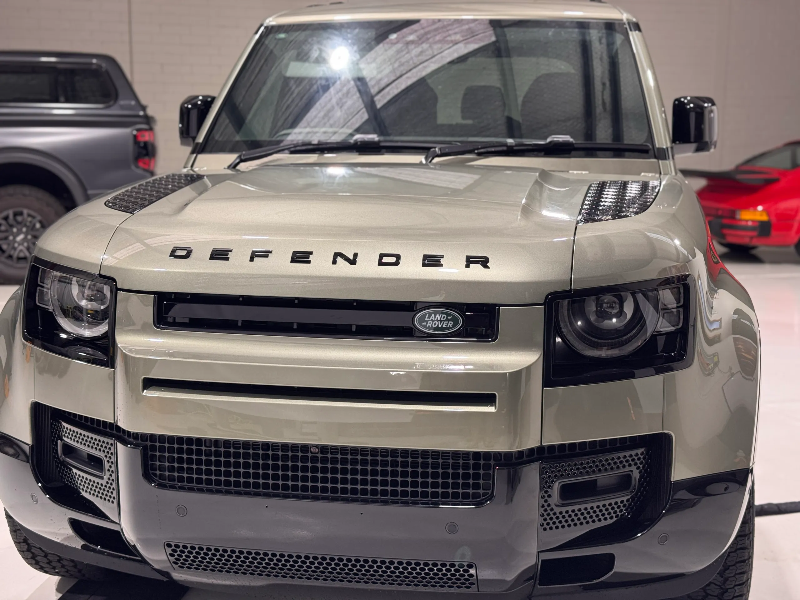 Head-on view of the green Land Rover Defender inside the workshop