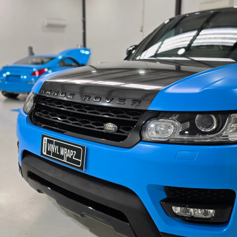 Satin blue Range Rover Sport front end with a black bonnet and grille in the workshop