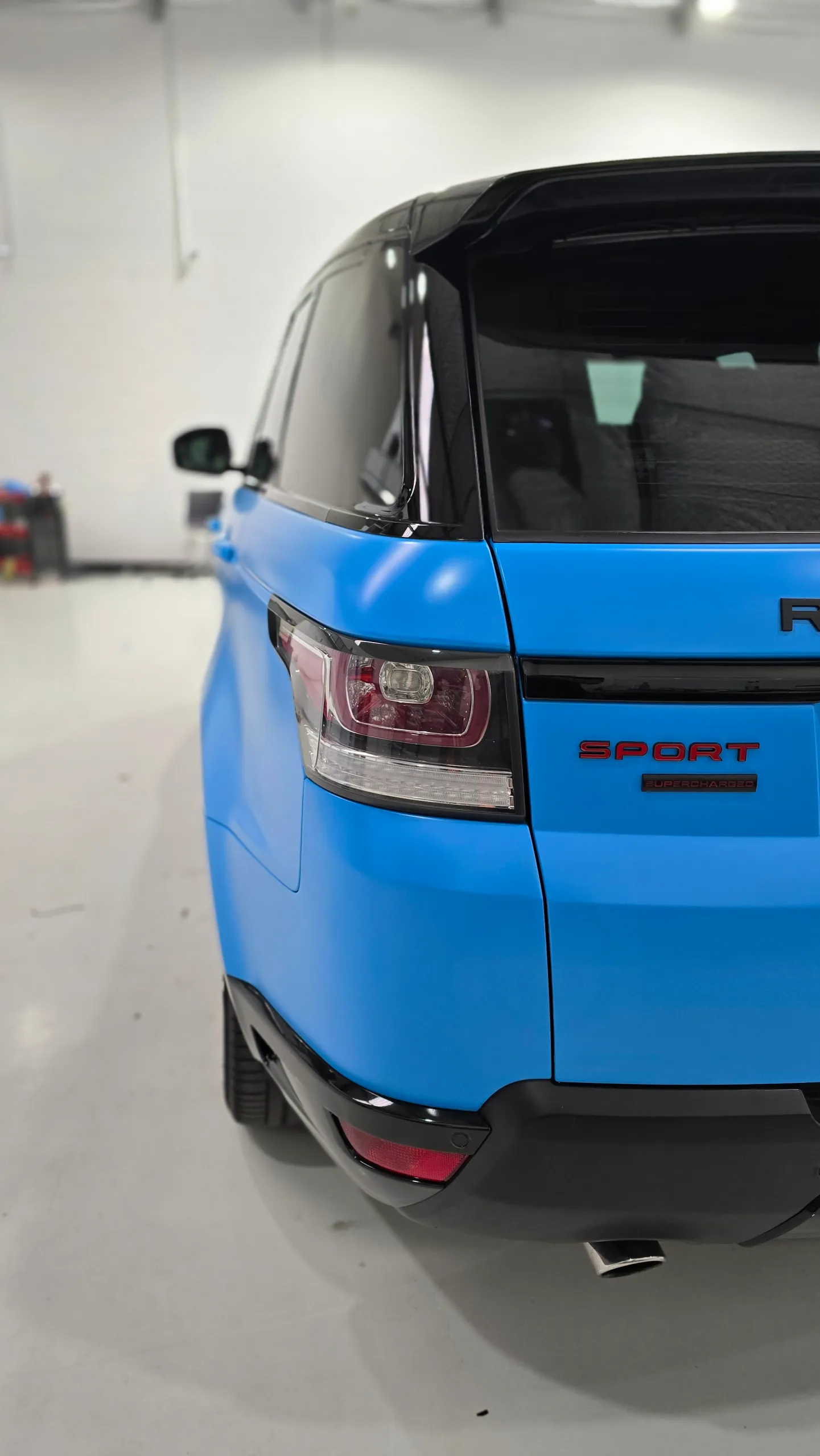 Rear light and Sport badge on the satin blue Range Rover Sport tailgate