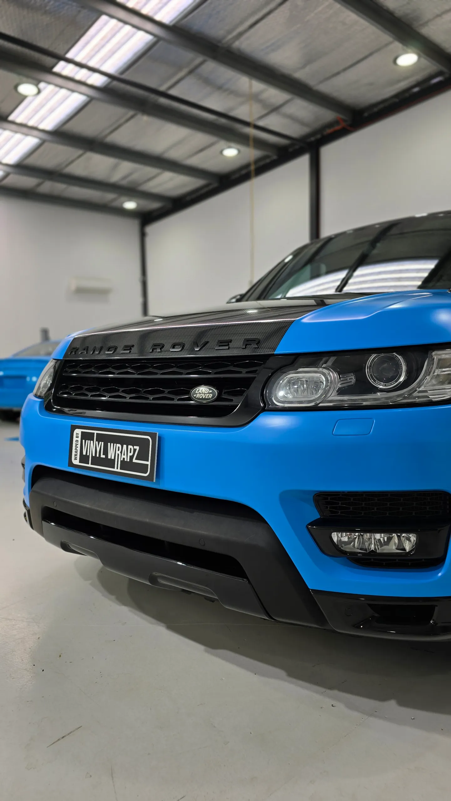 Satin light blue Range Rover Sport with black accents, front detail