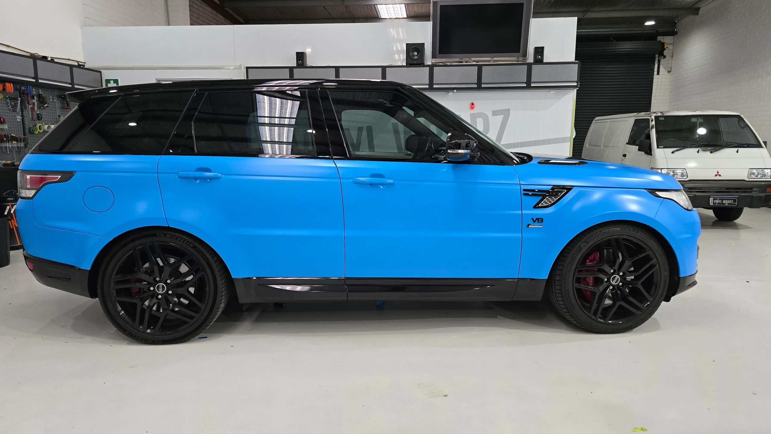 Satin light blue Range Rover Sport with black accents, side