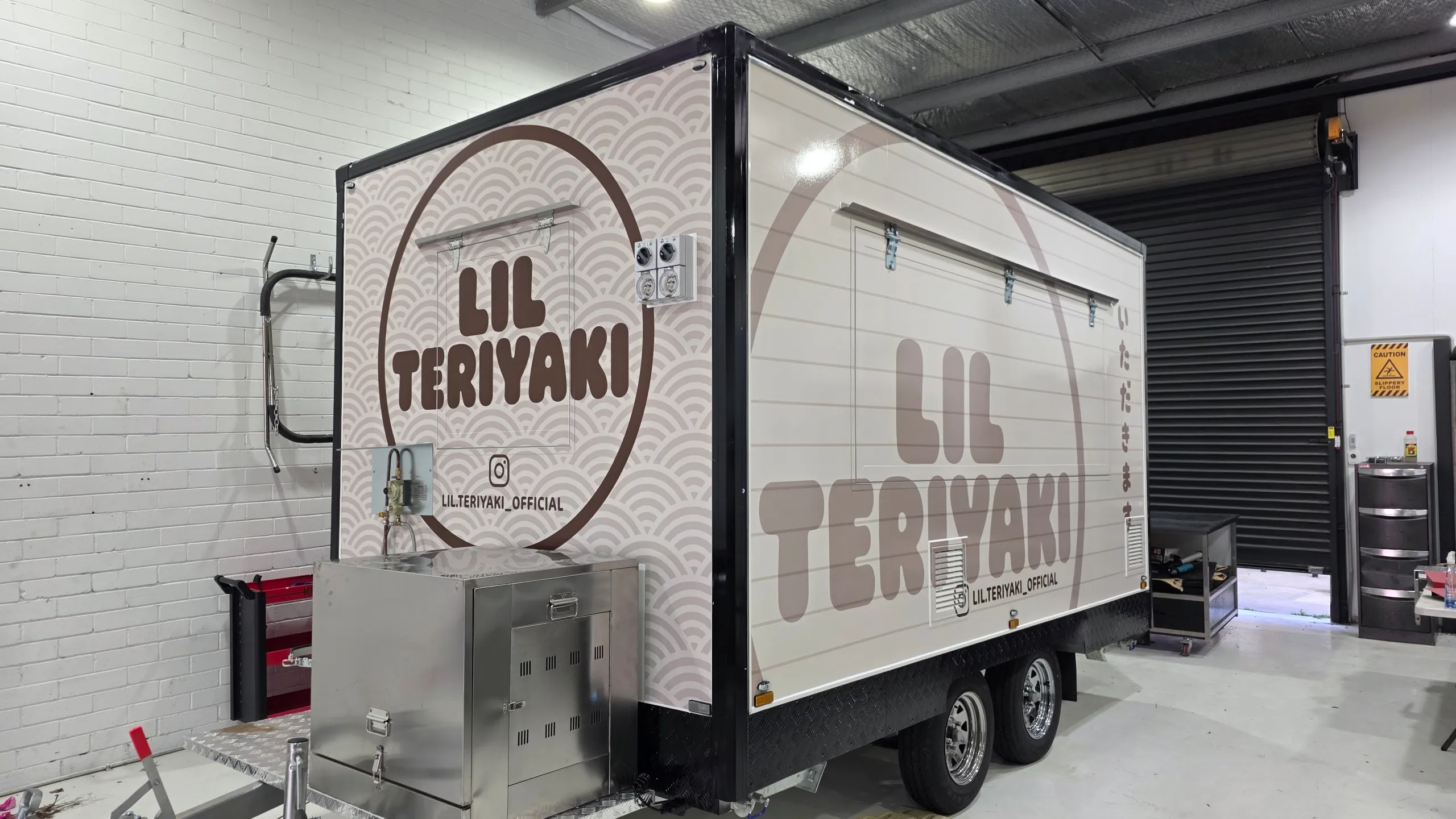 Lil Teriyaki food trailer with cream and brown branding and a repeating wave pattern