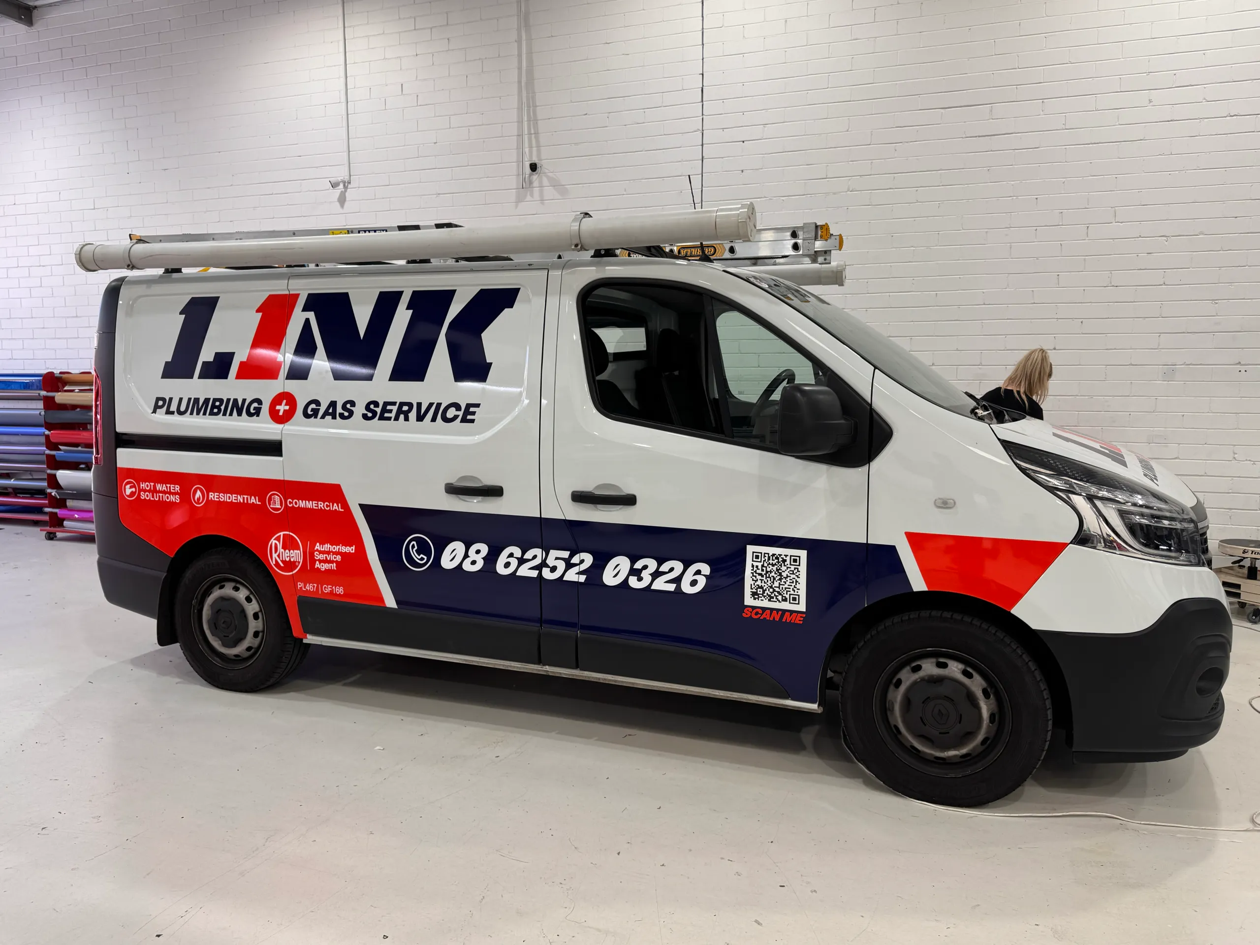 Side view of the Link Plumbing and Gas Service van with navy and orange-red graphics