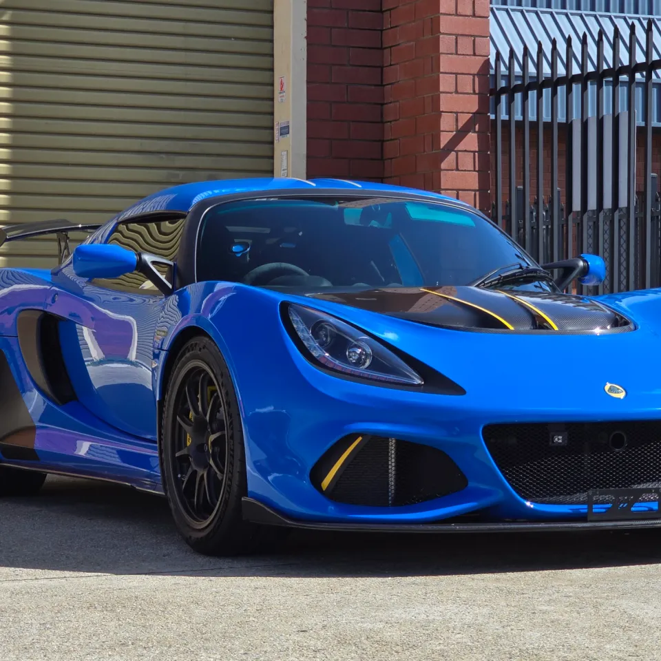 Blue Lotus Exige 420 Sport with yellow bonnet accents, viewed from the front quarter outdoors