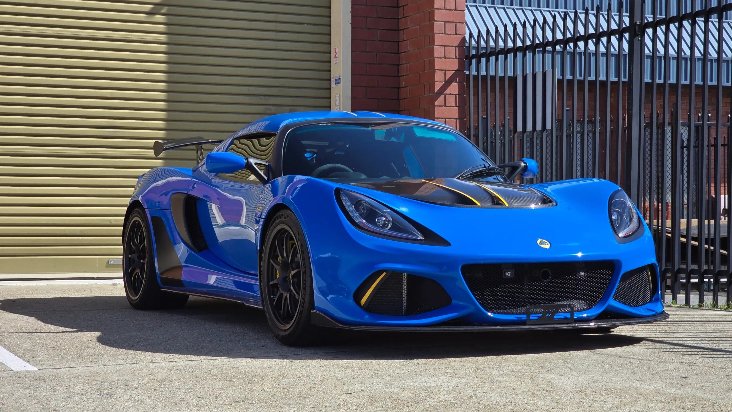 Blue Lotus Exige 420 Sport with yellow bonnet accents, viewed from the front quarter outdoors