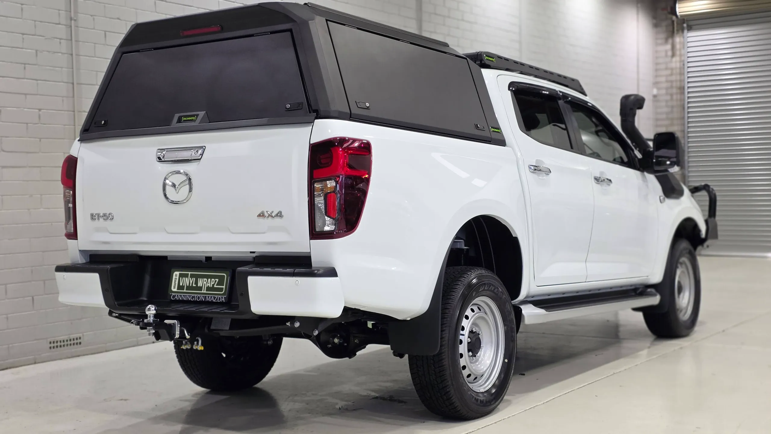 White Mazda BT-50 with a black canopy viewed from the rear quarter