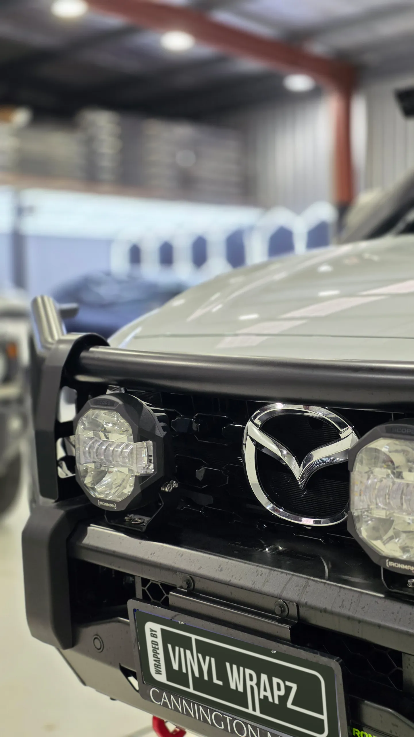 Close view of the Mazda badge and front bullbar on the white BT-50