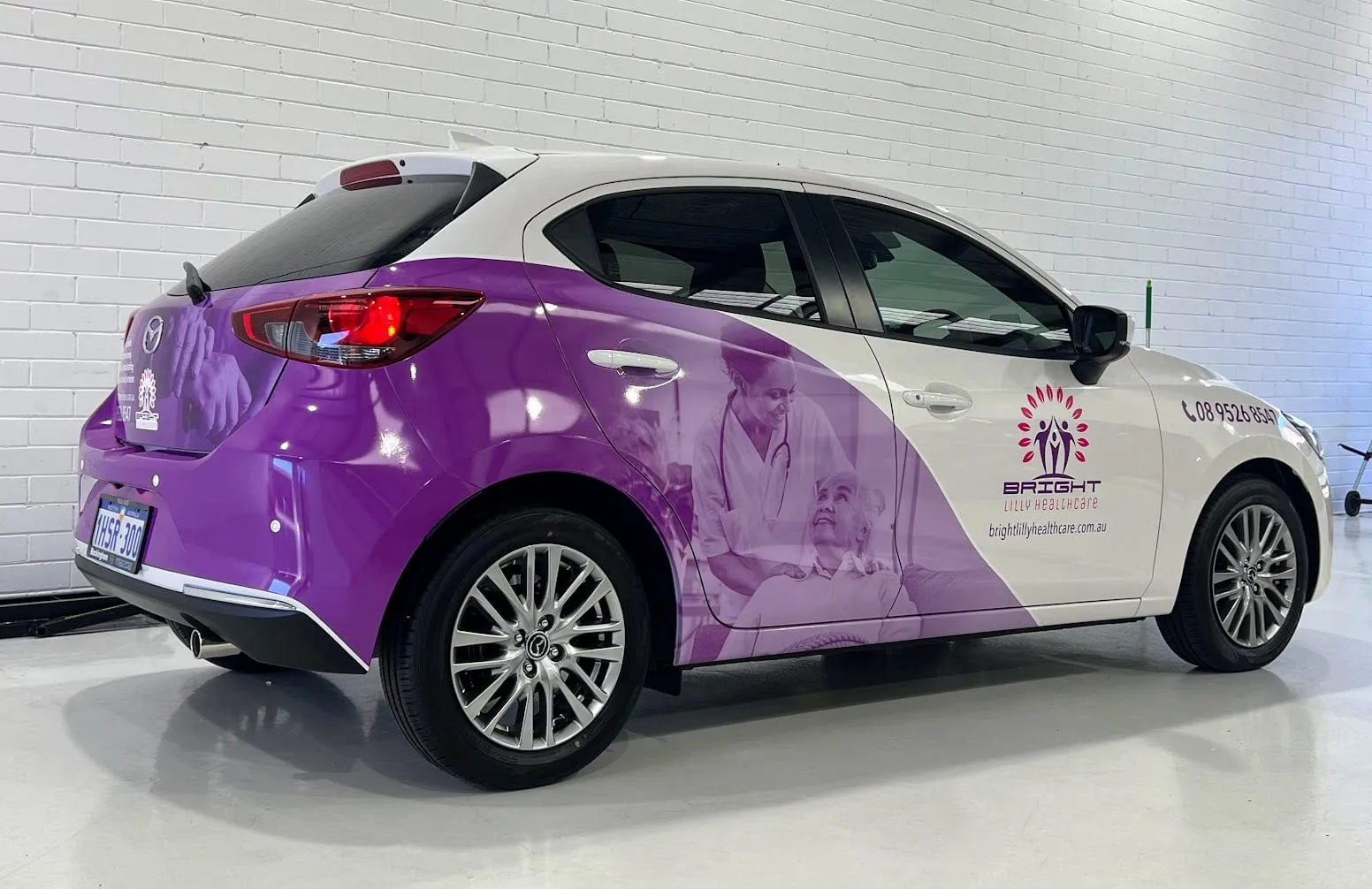 Mazda hatchback with a purple partial wrap smartly blended into the original white paint