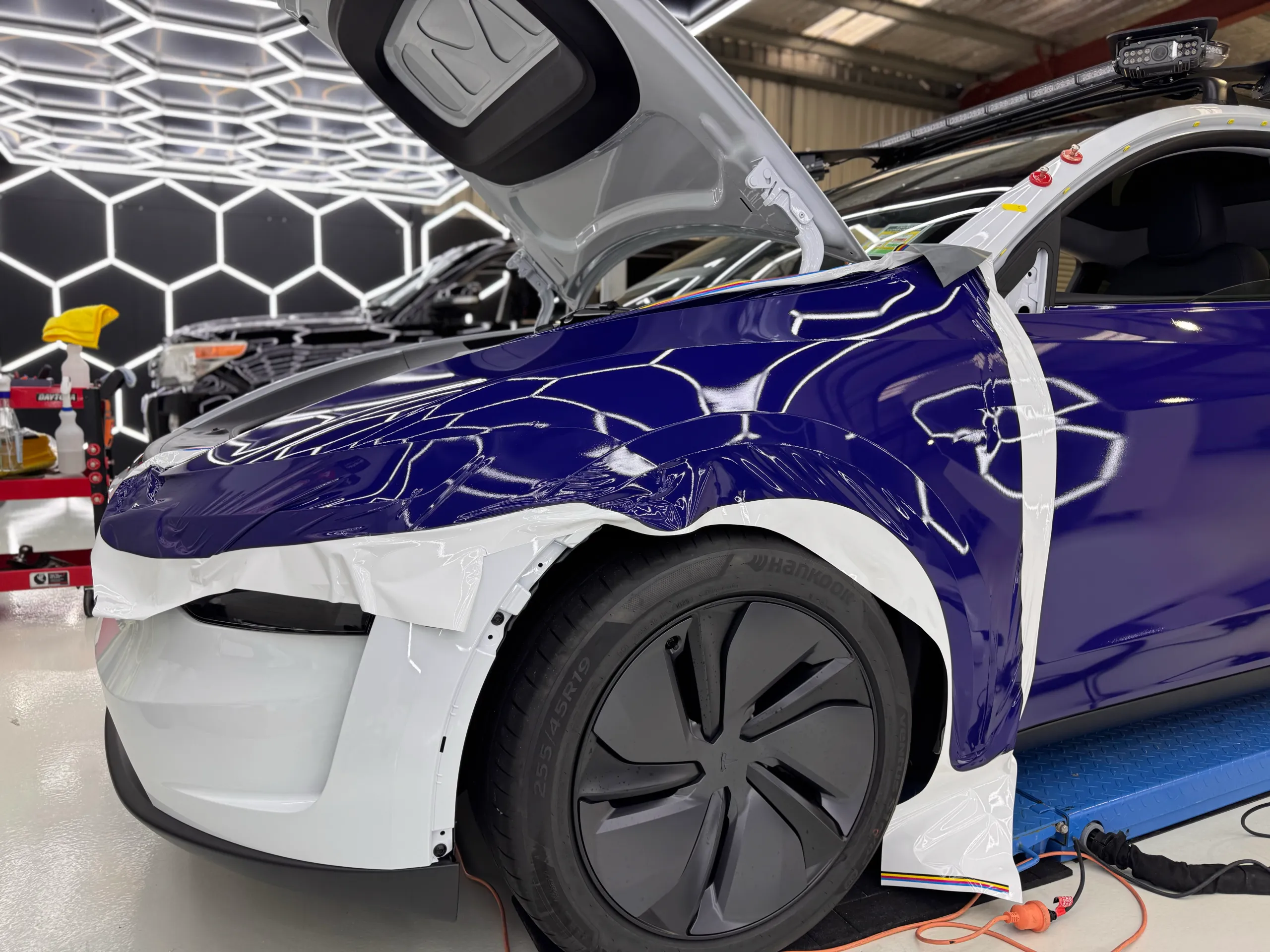 Loose blue film around the Tesla front guard during installation