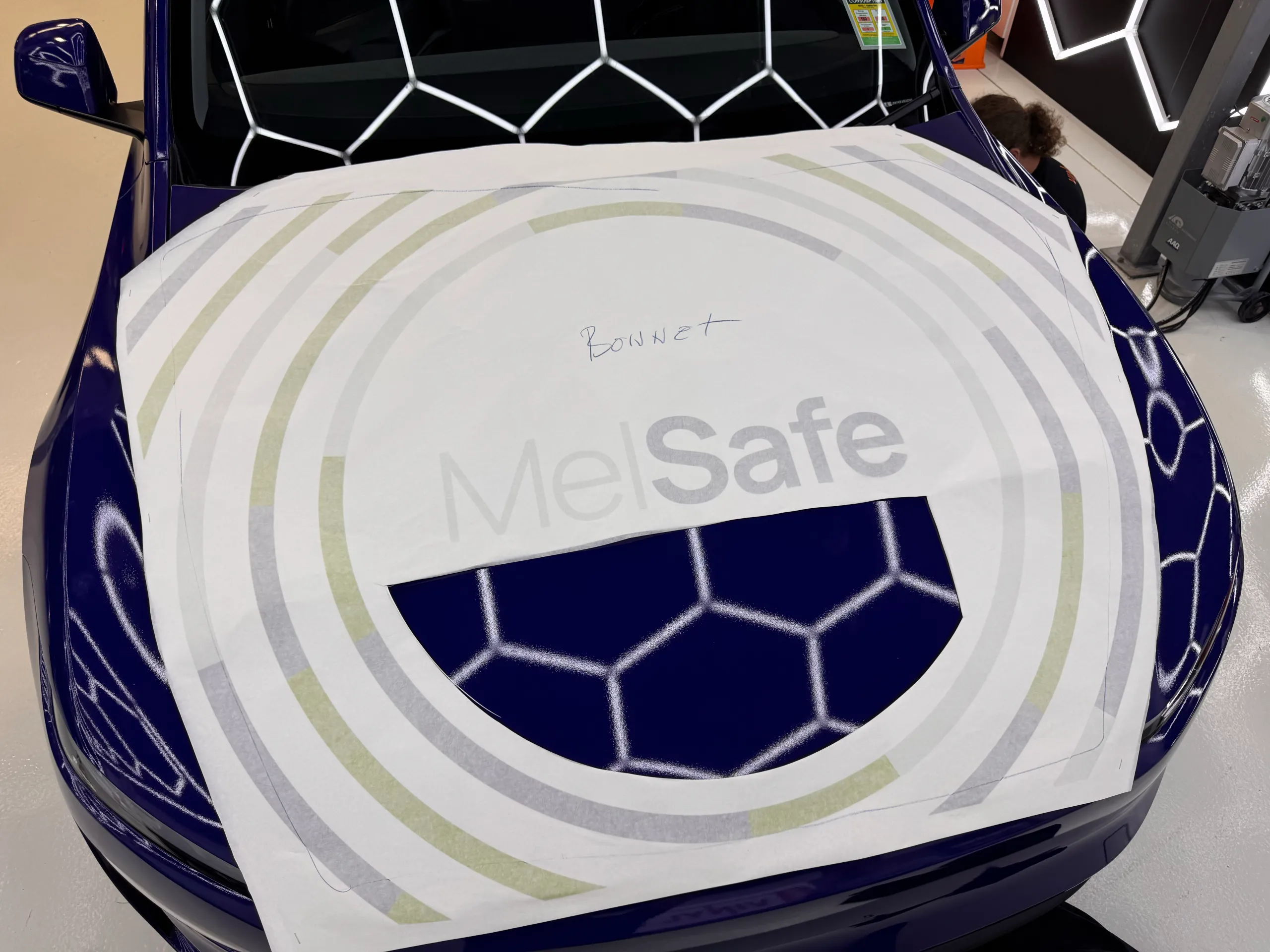 MelSafe bonnet graphics positioned on transfer paper over the blue Tesla