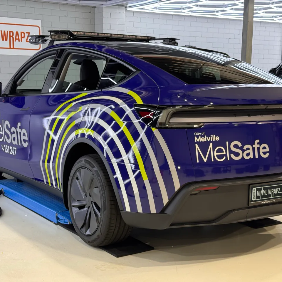 Blue City of Melville MelSafe Tesla Model Y viewed from the rear quarter in the workshop