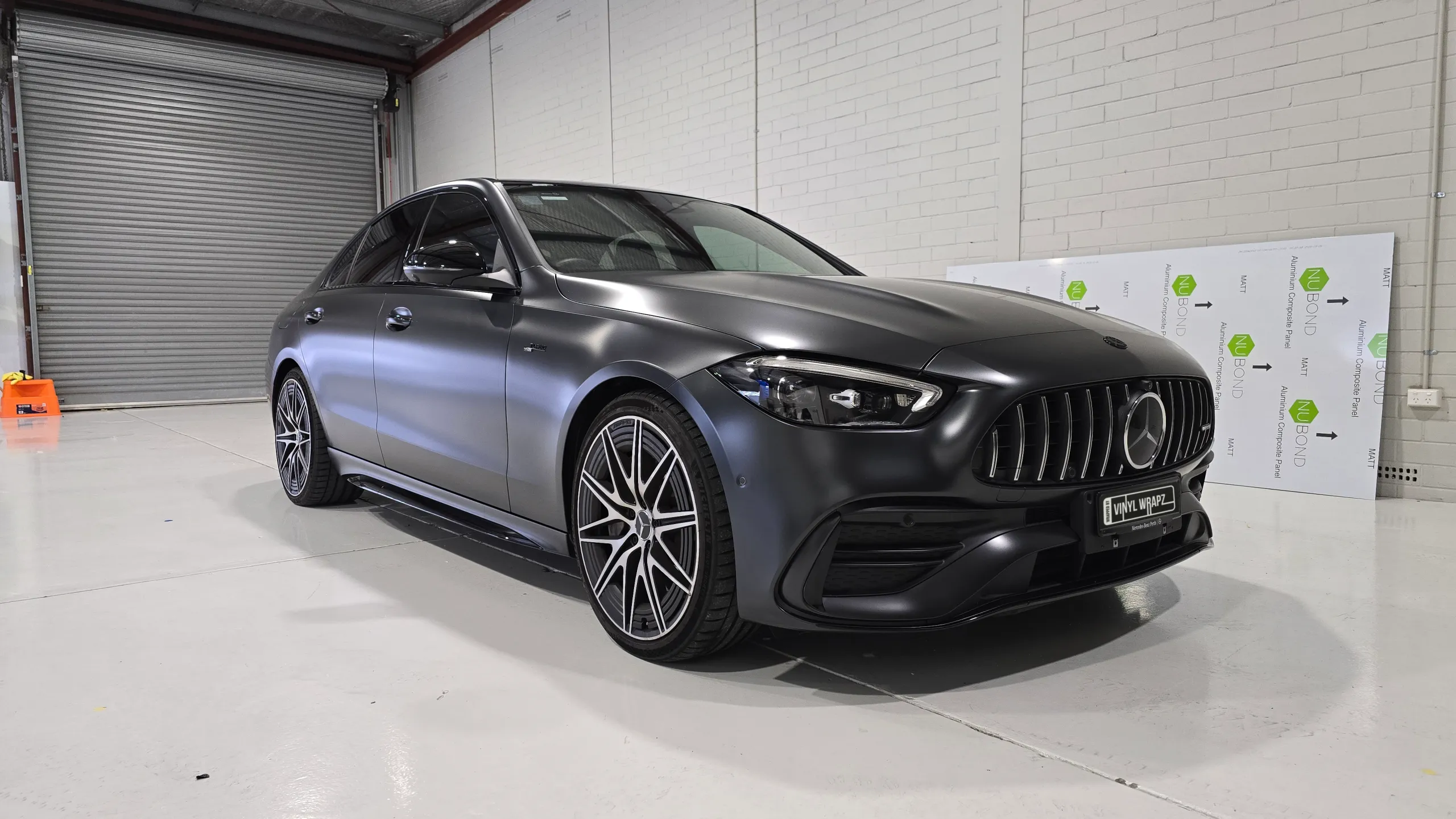Mercedes-AMG C43 with a satin dark grey colour-change wrap in the workshop